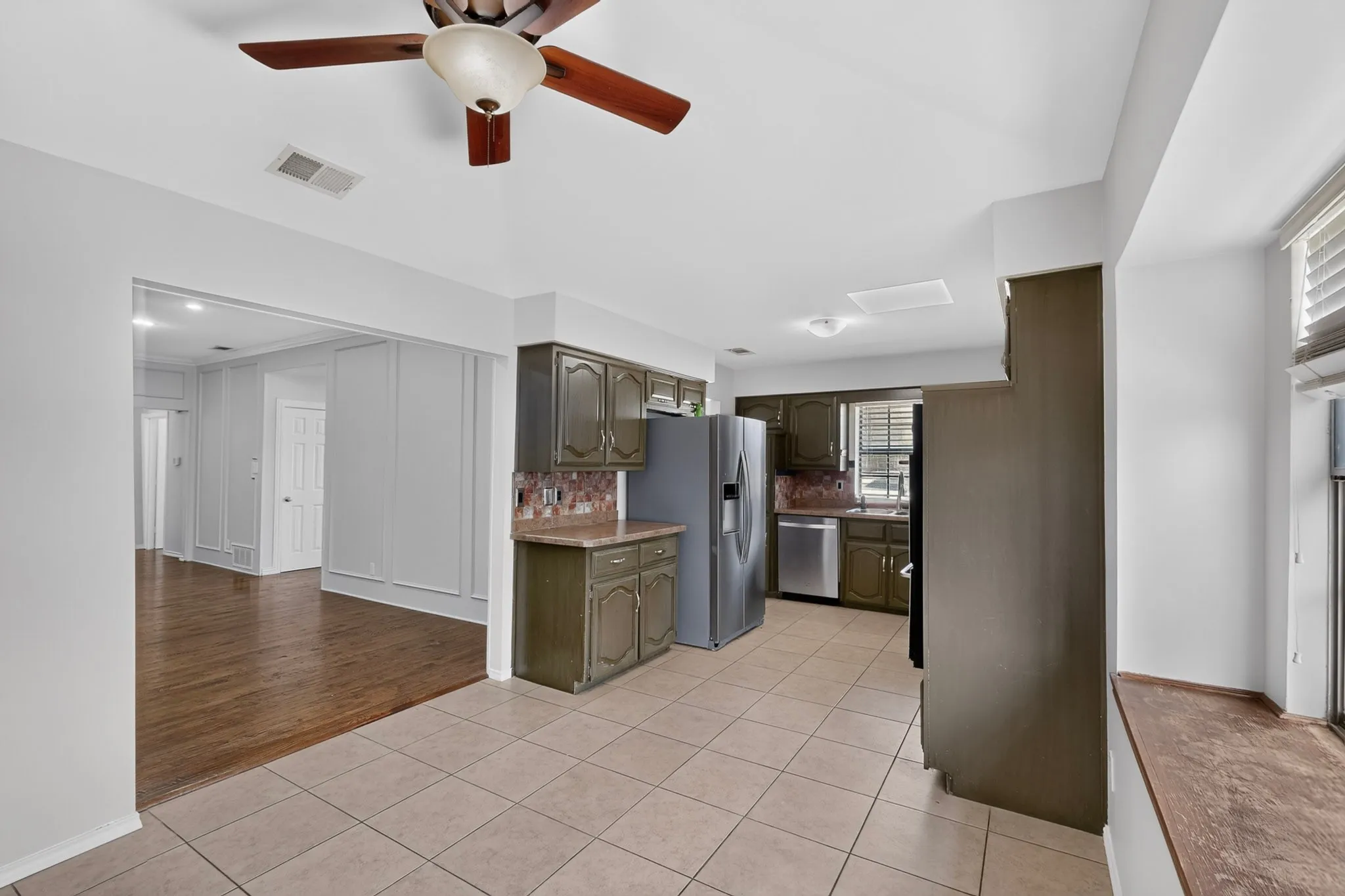 Kitchen featuring tile flooring, painted cabinetry, and stainless steel appliances