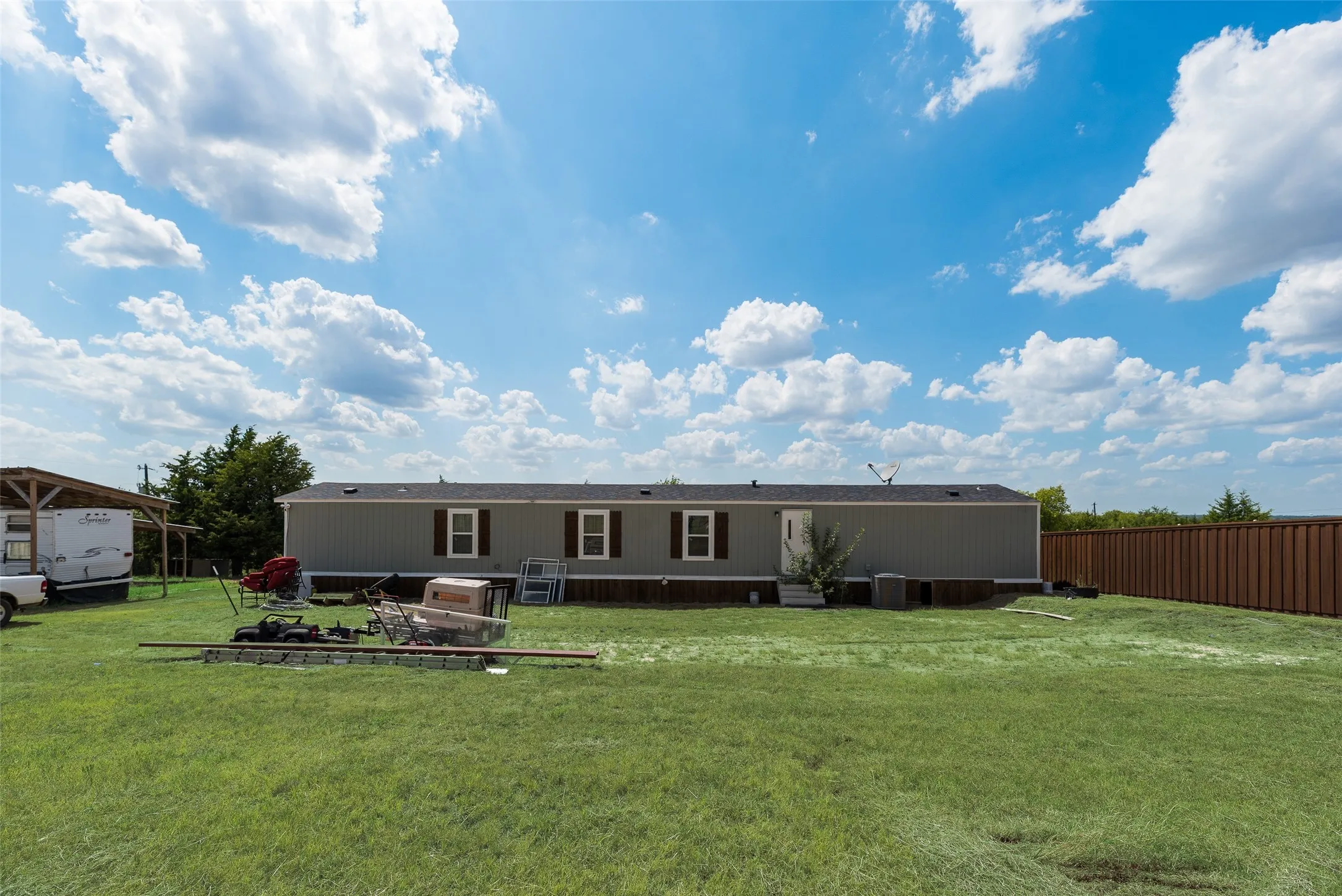 Expansive grass lawn with a full wooden privacy fence