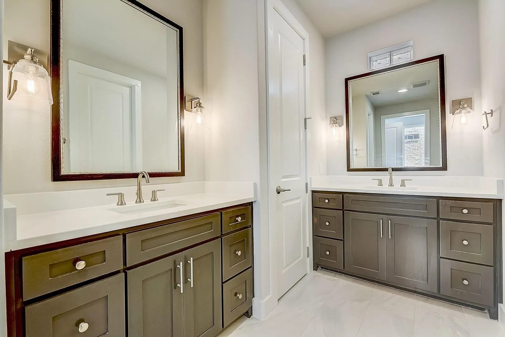 Dual vanity features white countertops, undermount sinks, and brushed nickel fixtures