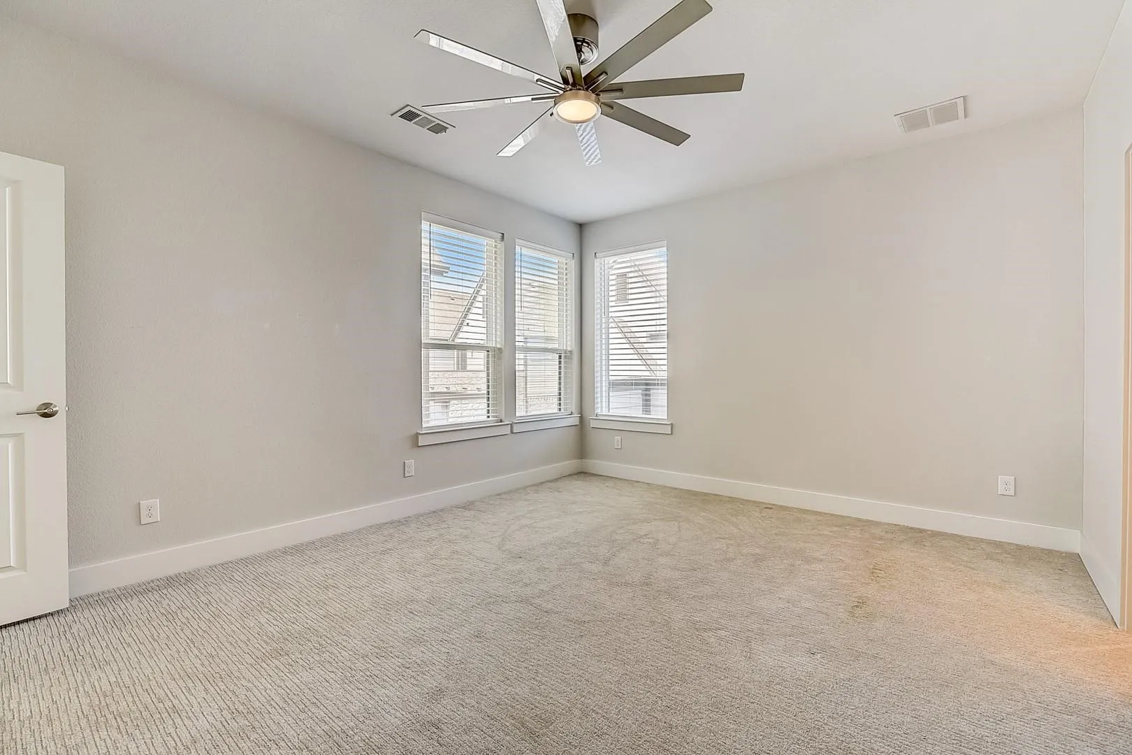 Neutral-toned walls complement plush carpet flooring