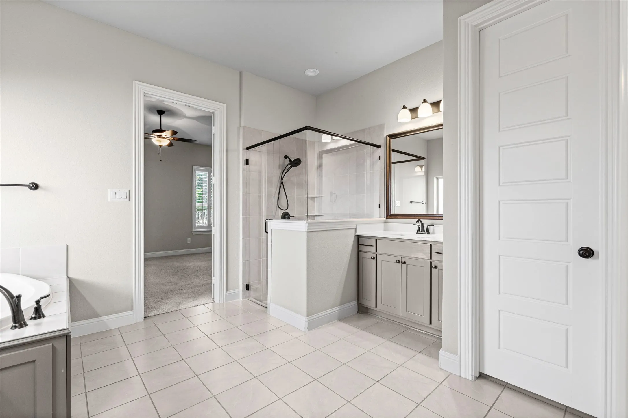 Massive primary bathroom has separate vanities, shower, garden tub, and two huge closets, one that connects to the laundry room