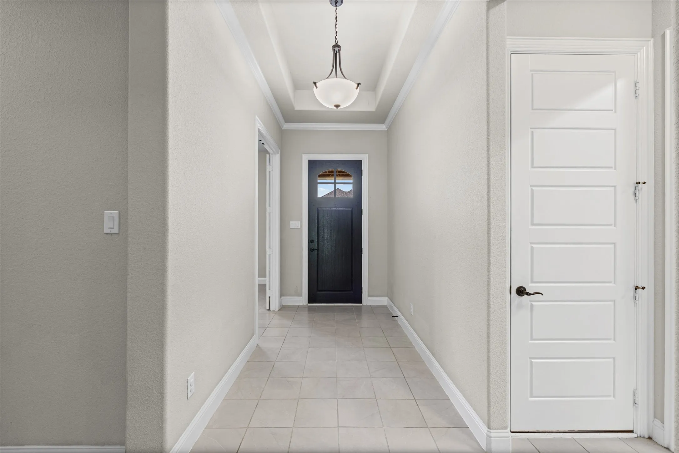 View of the front door and the doorway to the office or 4th bedroom at the front of the home
