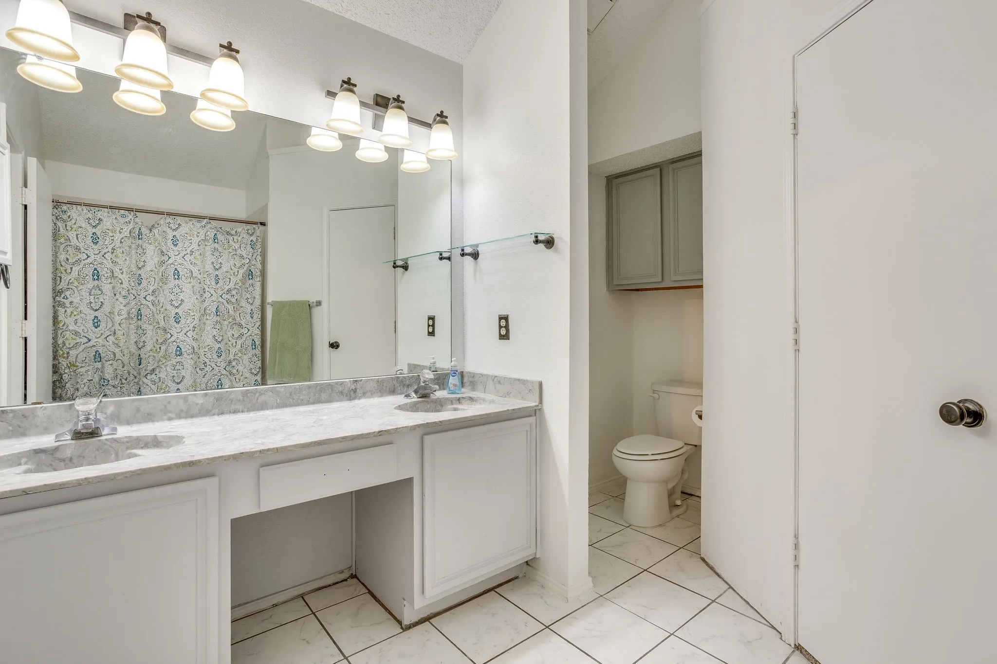 Dual vanity with a light-toned countertop, under-mount sinks, and individual mirrors