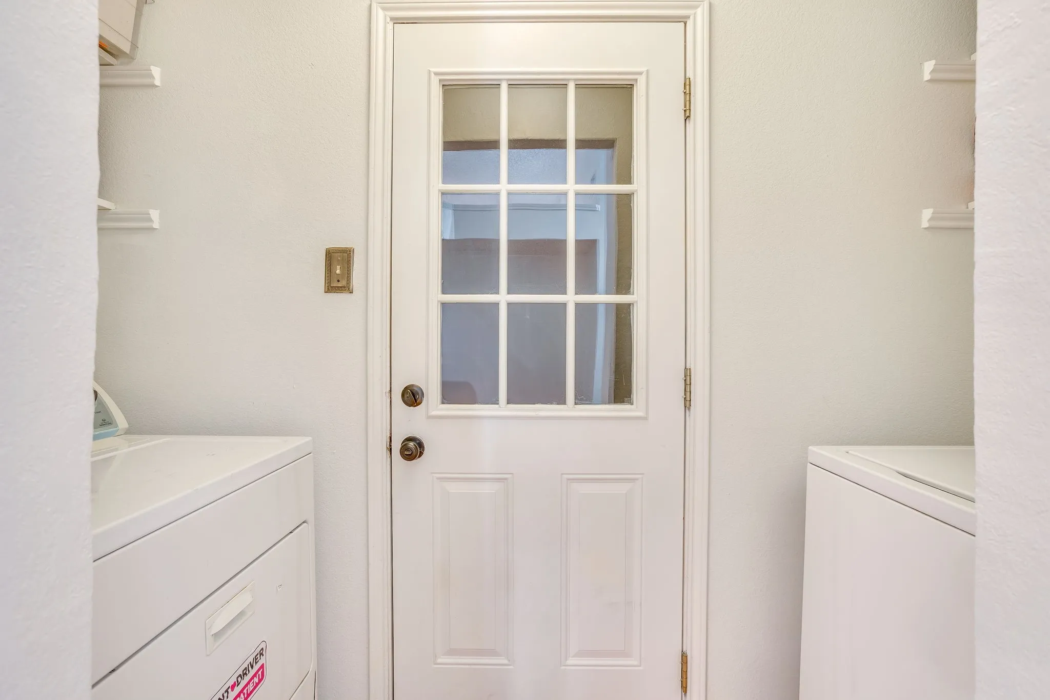 White paneled door with glass inserts and brass hardware