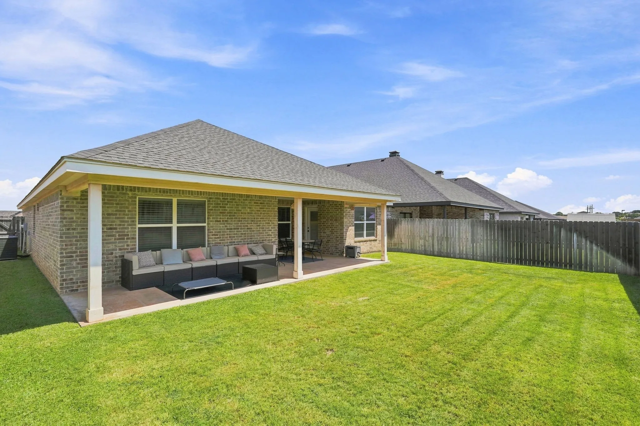 Expansive green lawn with a wood fence perimeter