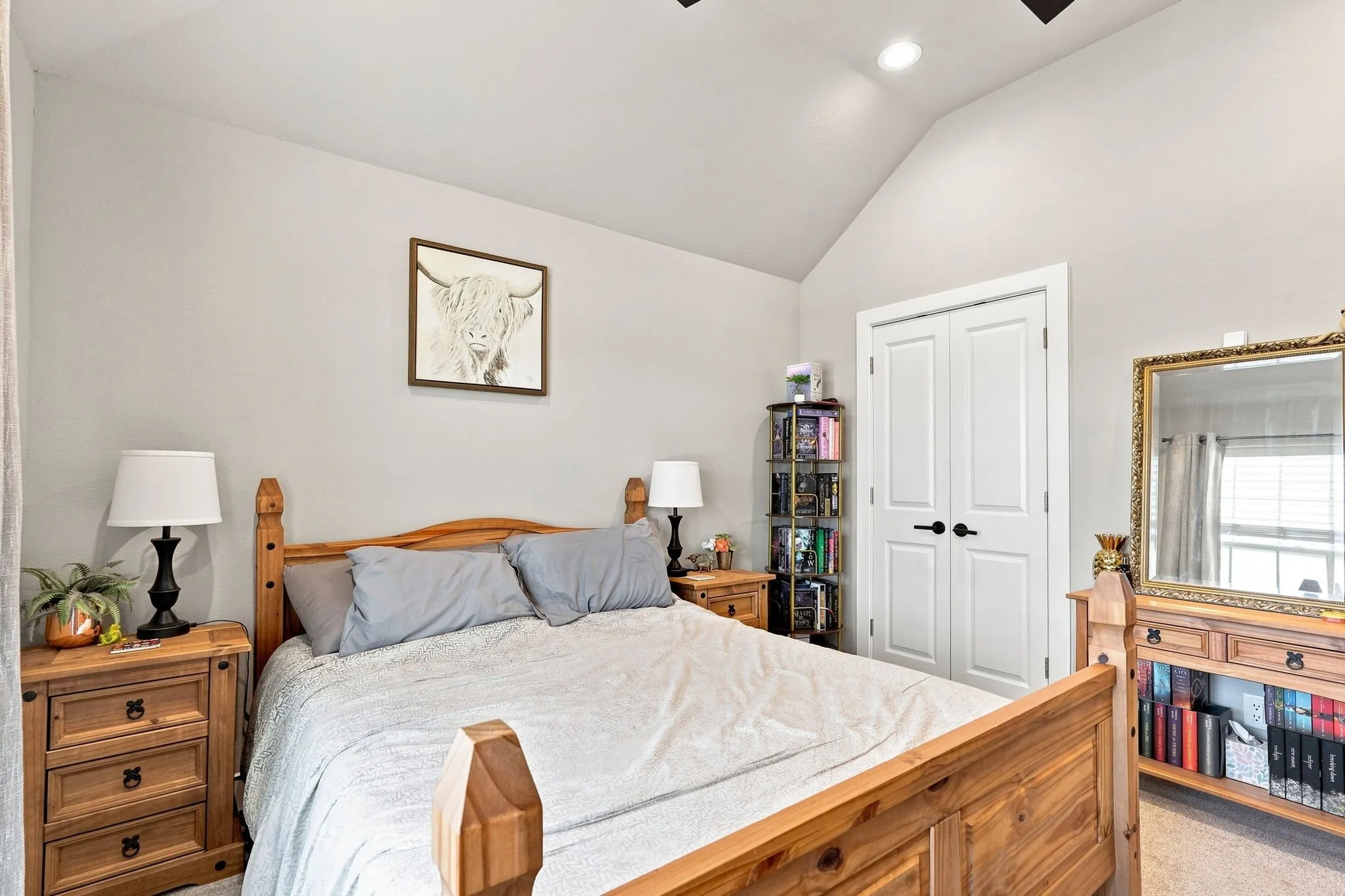 Vaulted ceiling with recessed lighting, light gray wall paint, and white double closet doors with matte black hardware