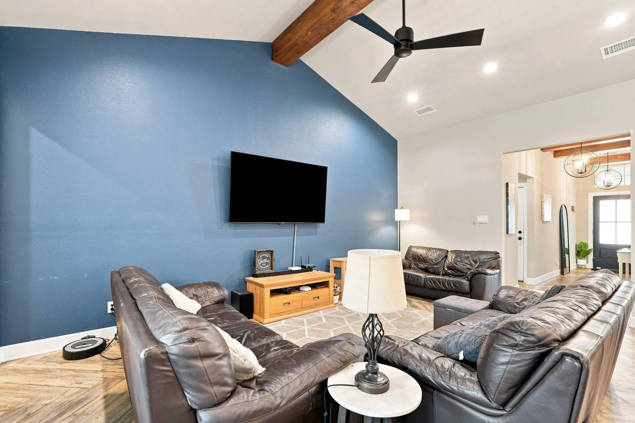 Vaulted ceiling with exposed wood beam, recessed lighting, and a ceiling fan