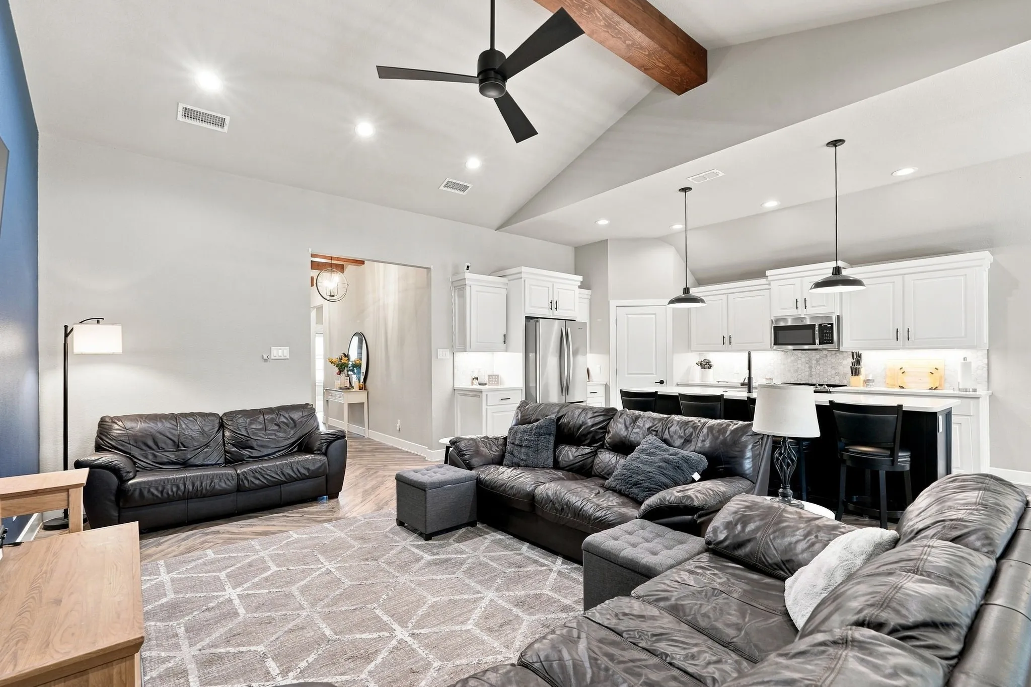 Vaulted ceiling featuring a prominent wood beam, recessed lighting, and a ceiling fan