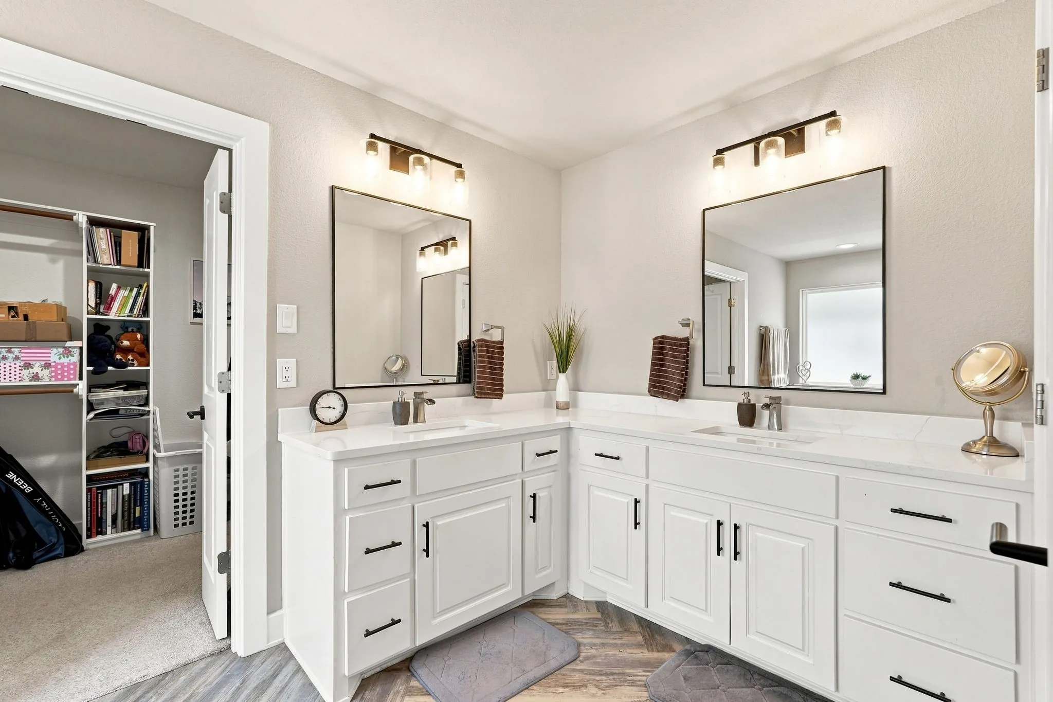 Dual vanity with white cabinetry and integrated sinks, complemented by contemporary mirrors and vanity lighting