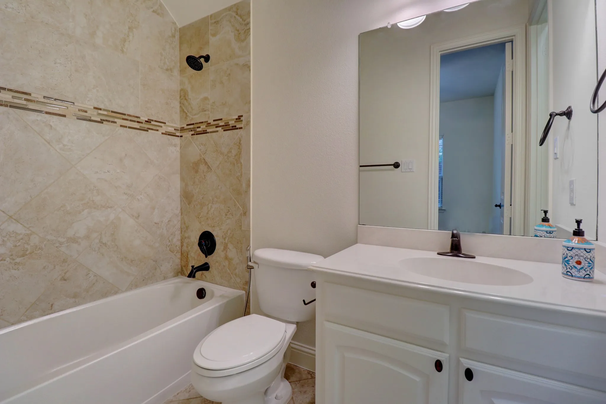 White vanity with an integrated sink, large mirror, and bronze fixtures