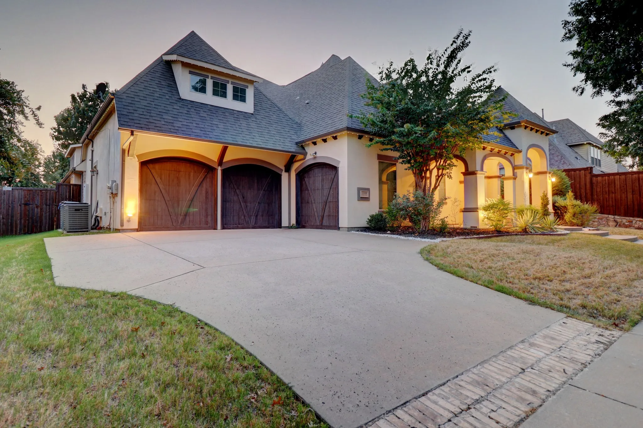 Stucco exterior with arched entryways and wooden garage doors