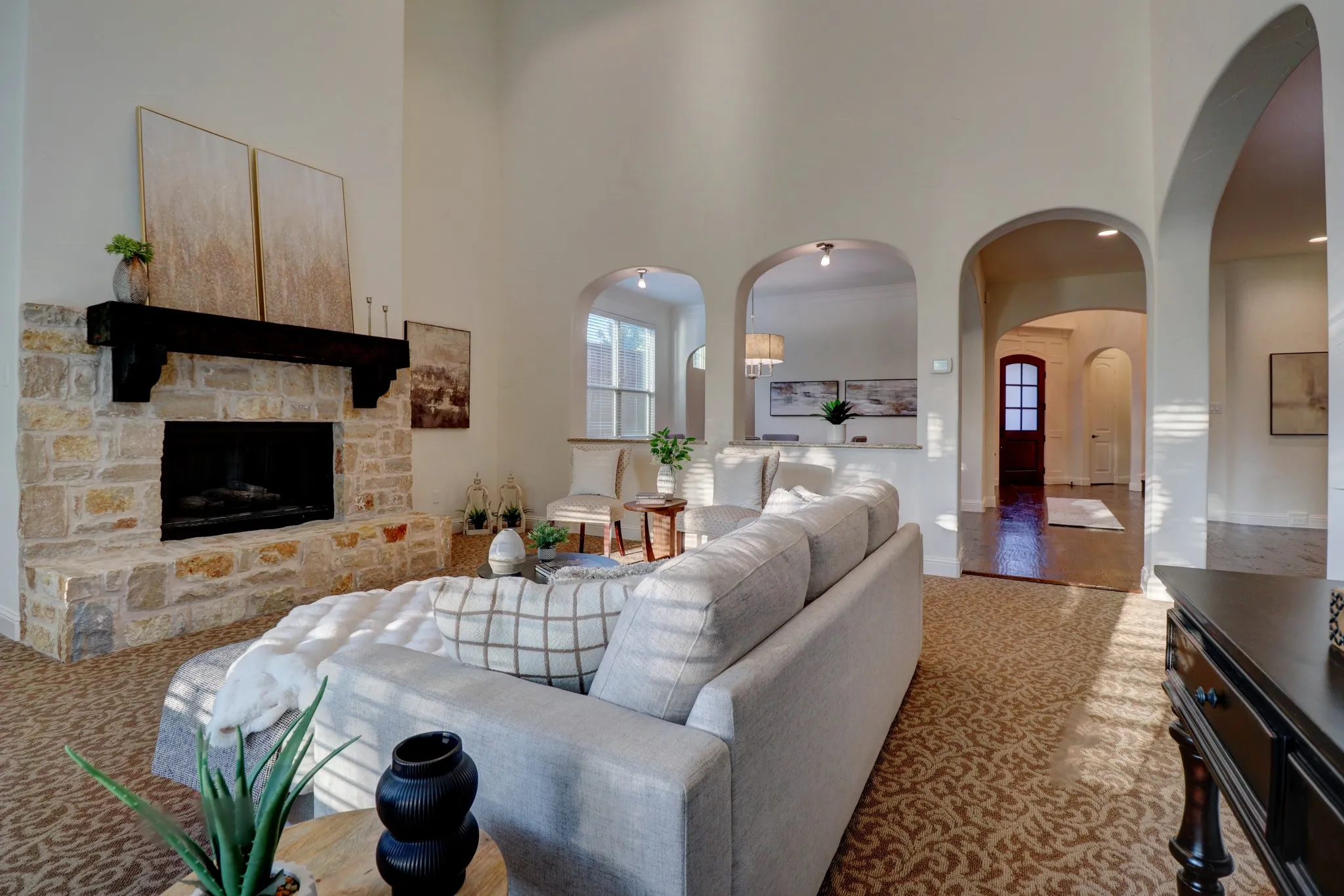 Stone fireplace with a dark wood mantel and high ceilings