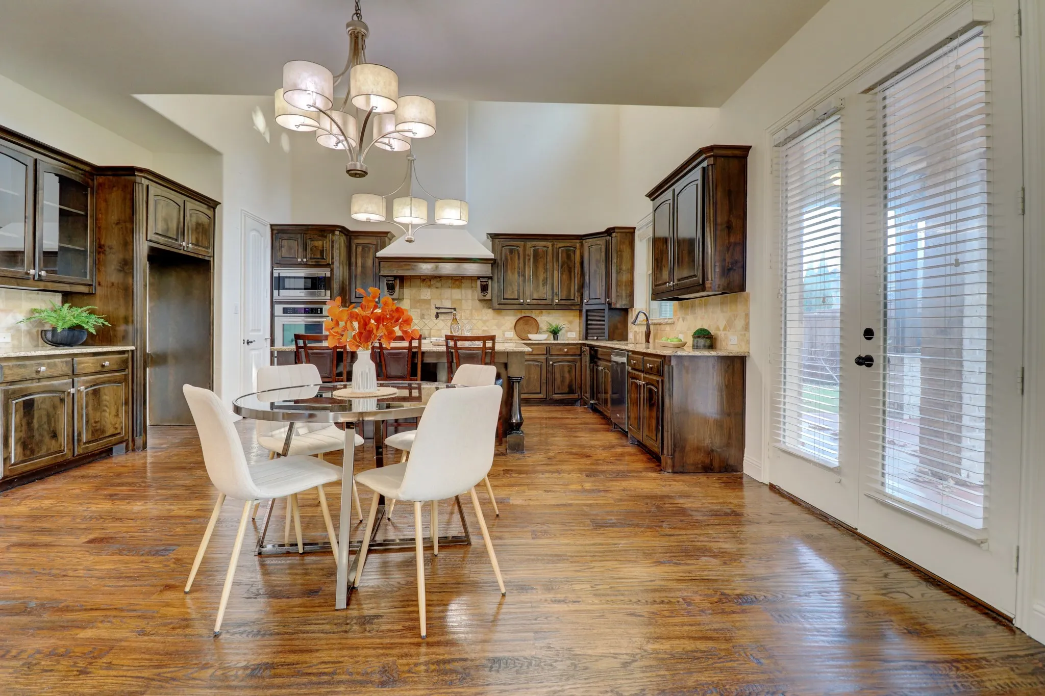 Kitchen featuring rich wood-finish flooring, dark wood cabinetry, built-in stainless steel appliances, and a central island with a breakfast bar