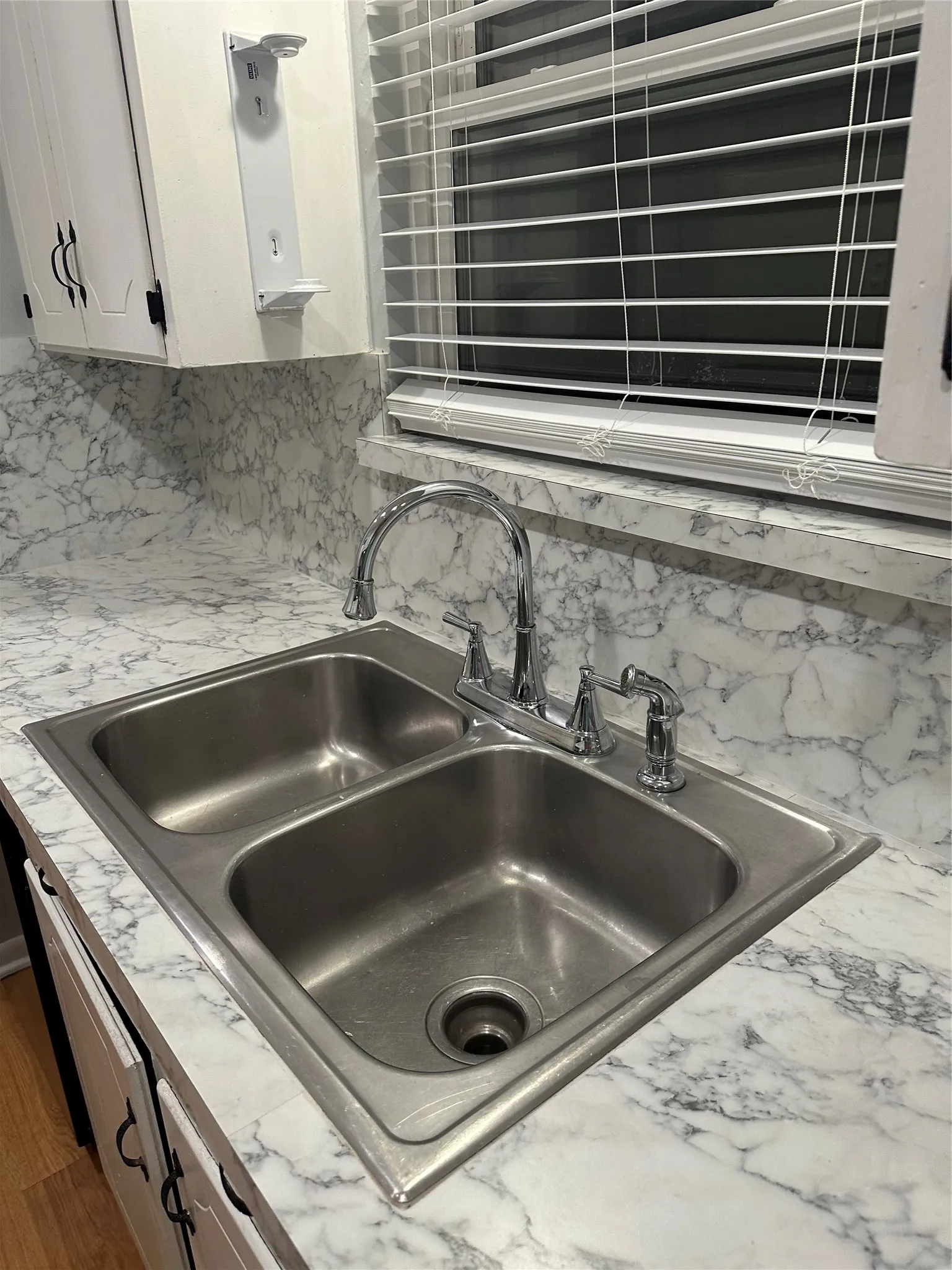 Stainless steel double basin sink with chrome faucet and integrated soap dispenser