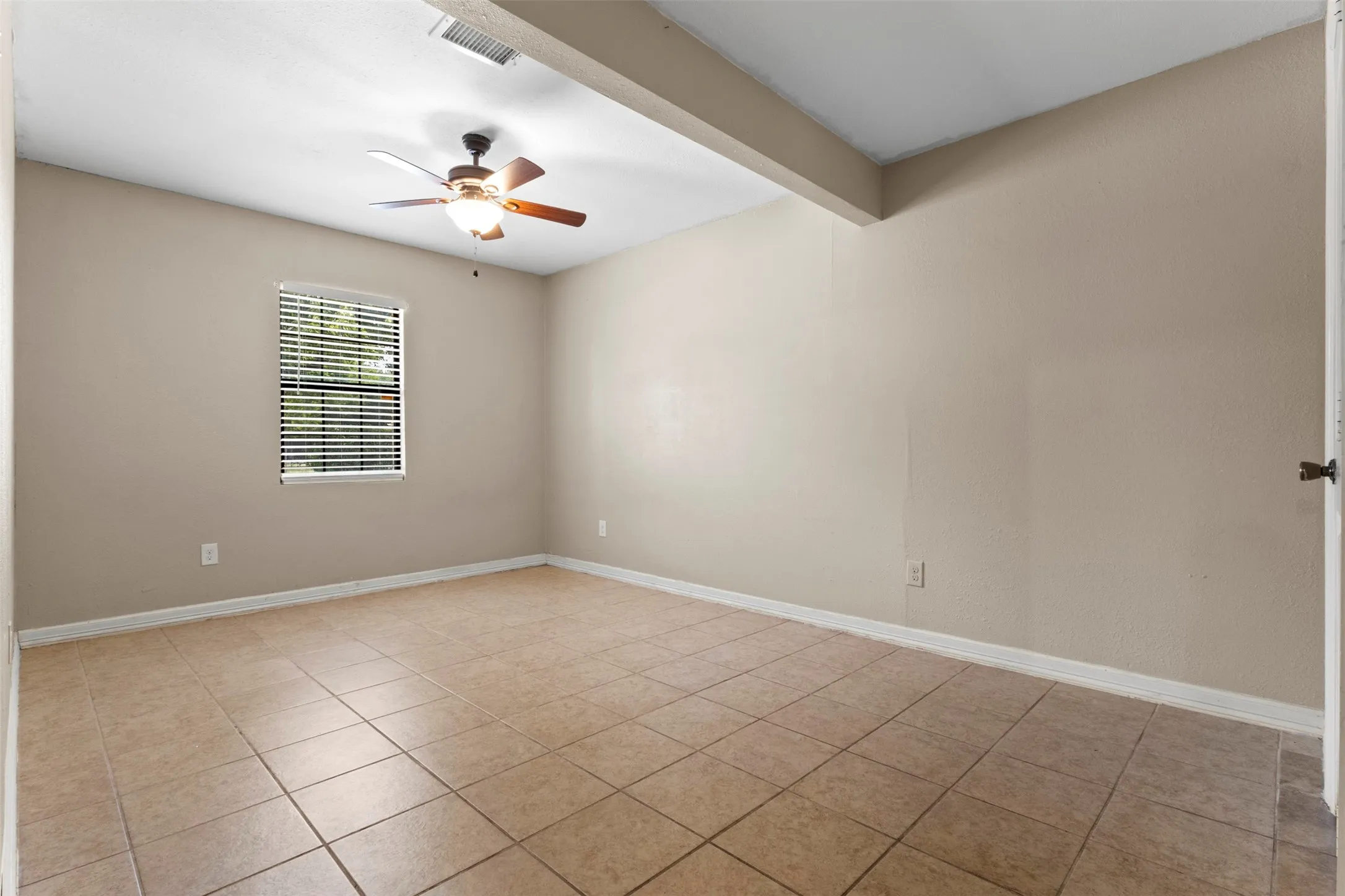 Tile flooring, ceiling fan with integrated lighting, window with blinds, neutral wall paint