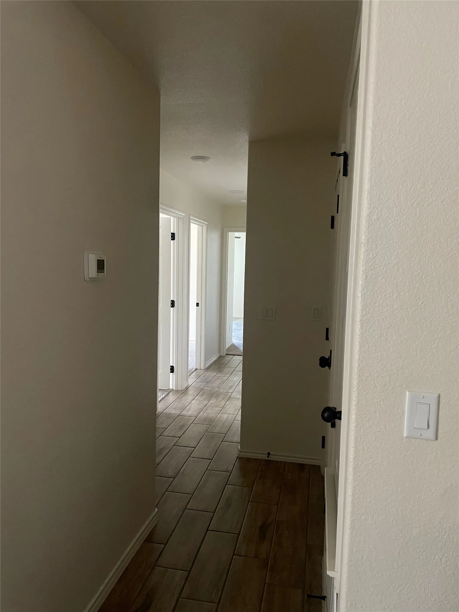 Hallway featuring wood-finish tile flooring, recessed lighting, and white trim