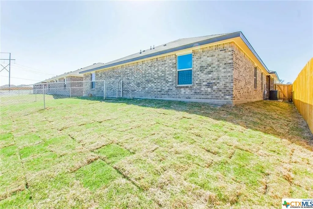 Expansive backyard featuring freshly laid sod and a privacy fence