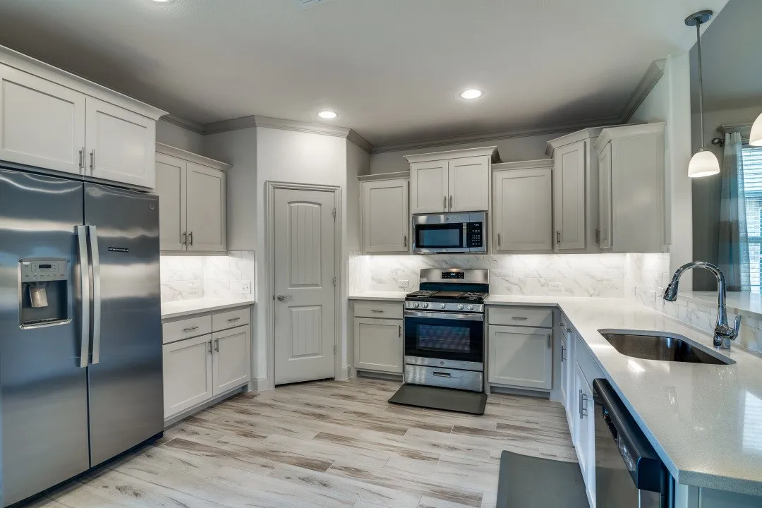 Kitchen featuring light-finish cabinetry, stainless steel appliances, light countertops, wood-finish flooring, and recessed lighting