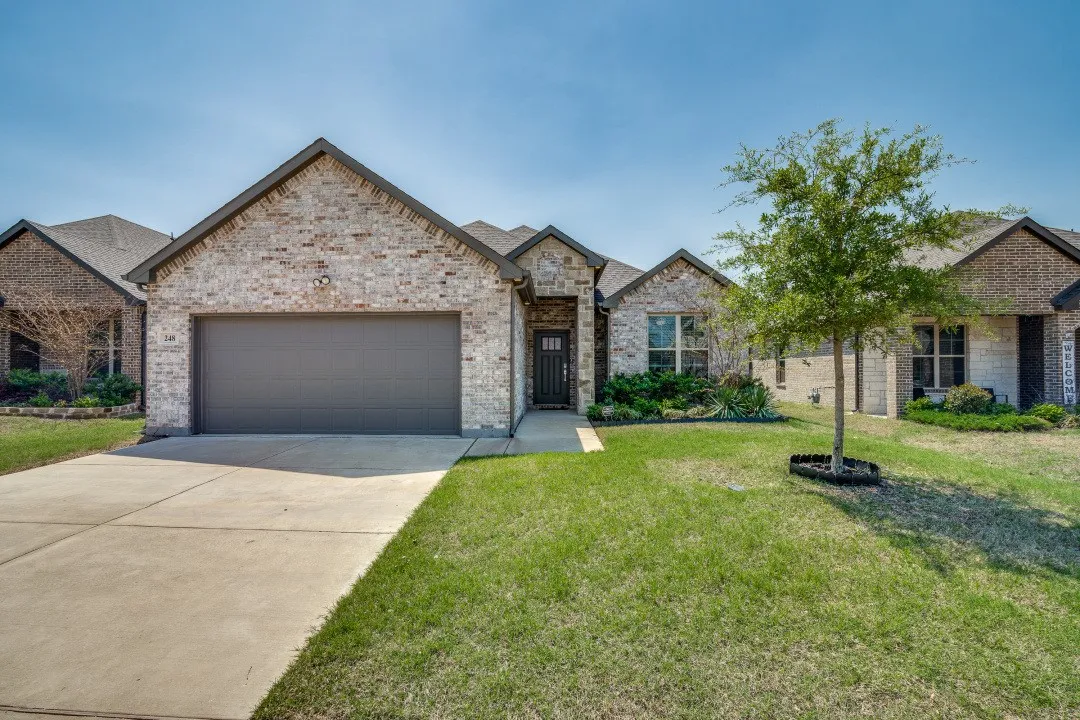 Brick exterior with an attached garage and a concrete driveway