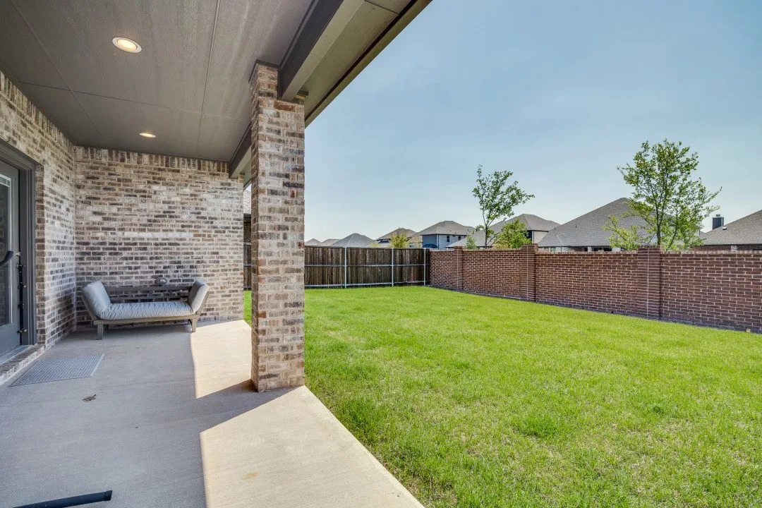 Covered patio with recessed lighting, brick exterior, and concrete flooring