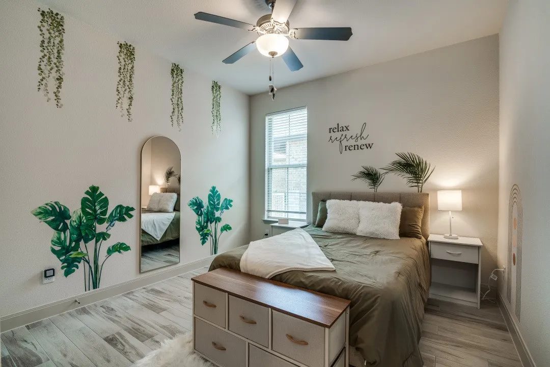 Wood-finish flooring, ceiling fan with integrated lighting, window with blinds, and light-toned walls