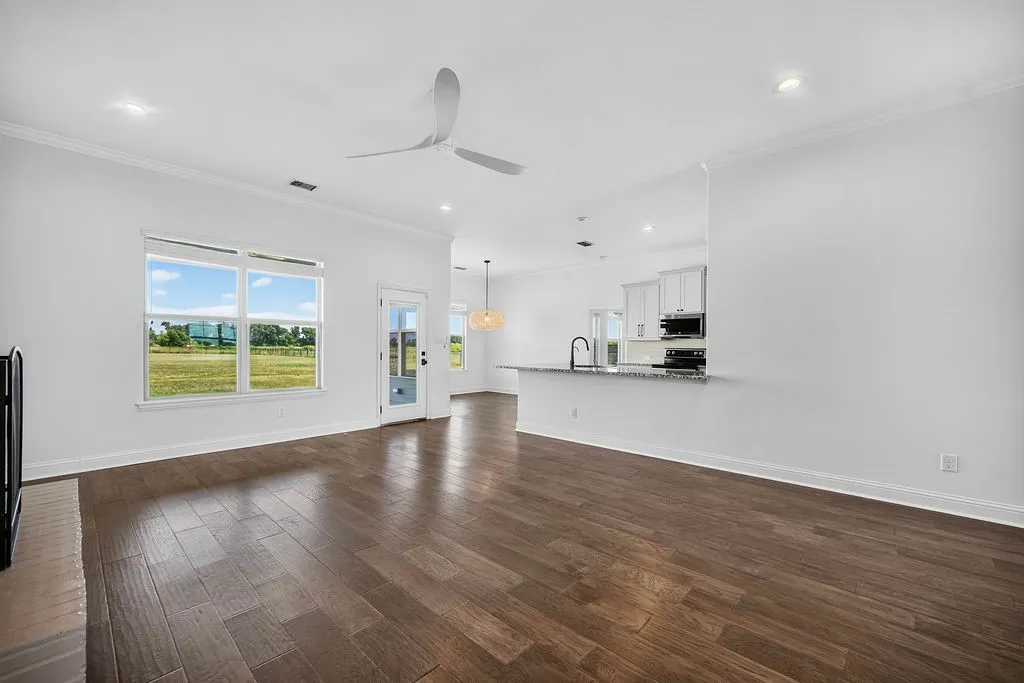 Open-concept living area with wood-finish flooring, a contemporary ceiling fan, and recessed lighting