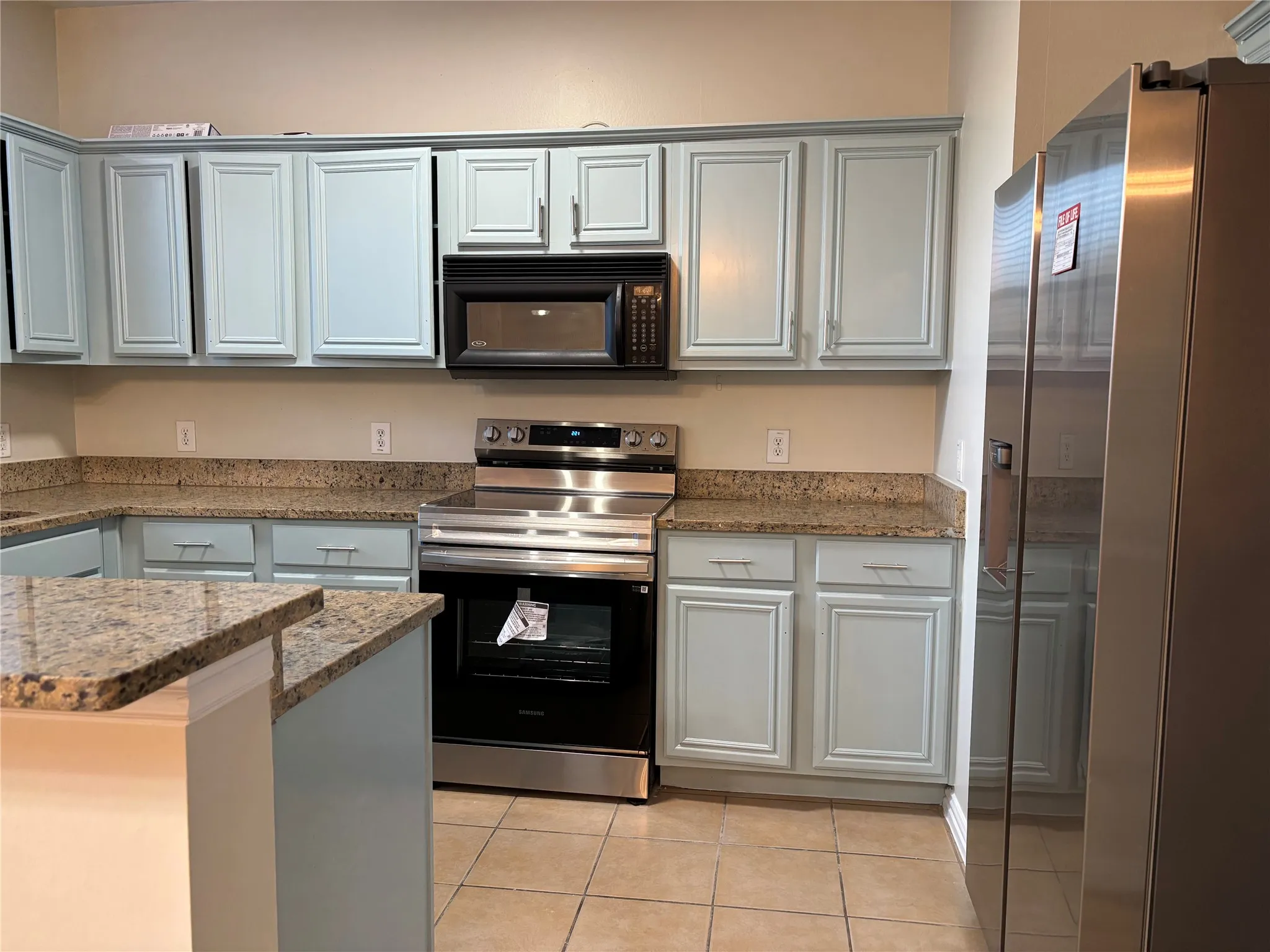 Kitchen featuring light tile patterned floors and stainless steel appliances