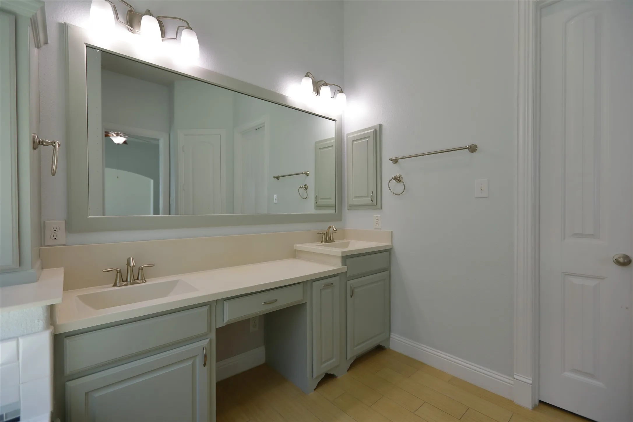Dual vanity with integrated sinks, light-toned countertops, and soft gray cabinetry