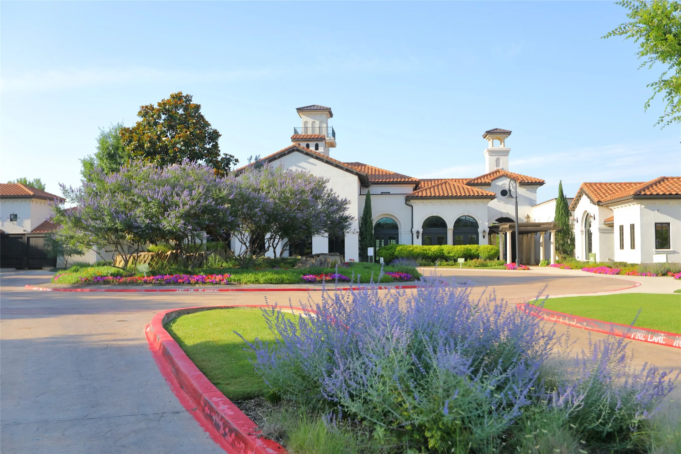 Mediterranean-style architecture featuring white stucco, red tile roofing, and arched windows