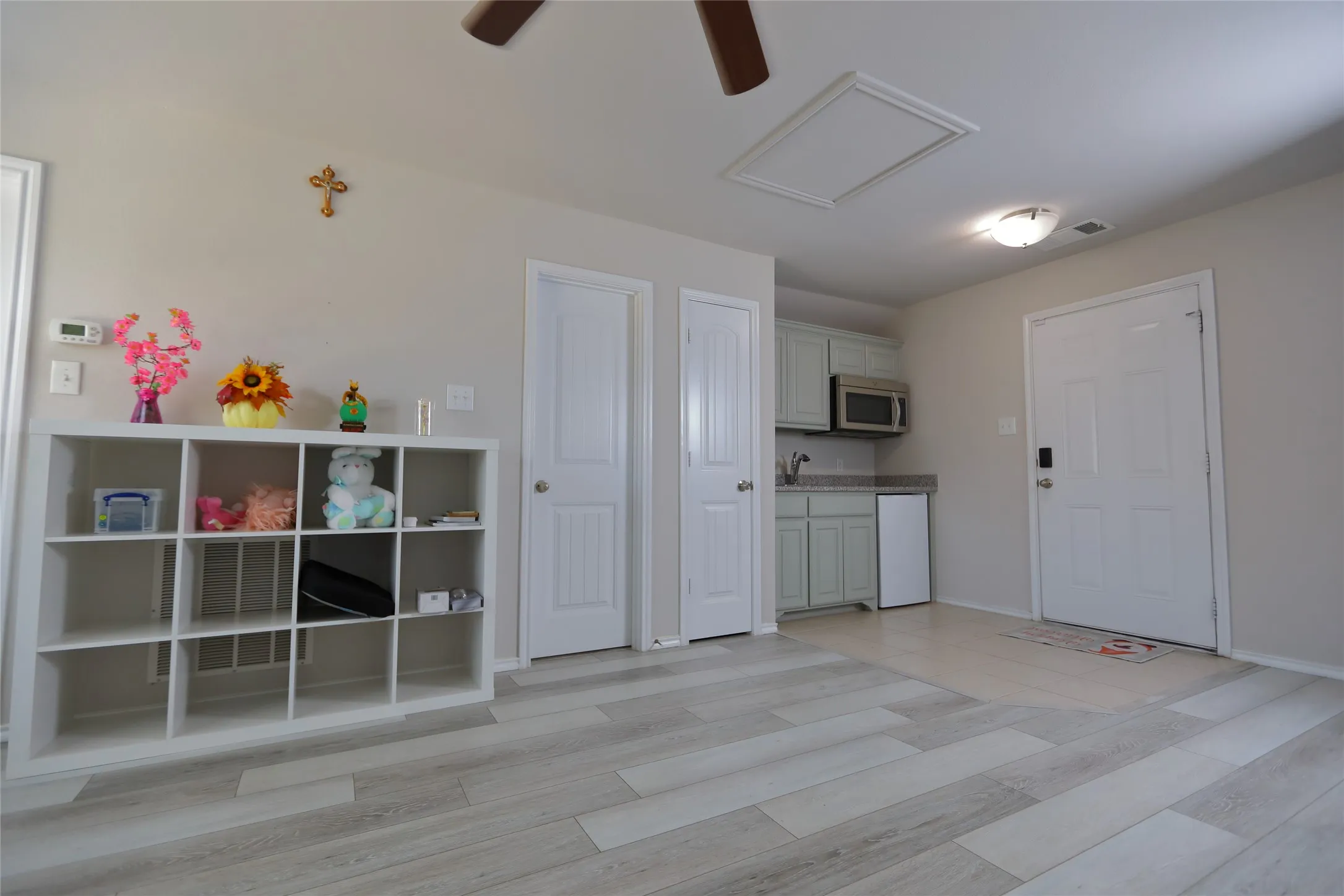 Light wood-finish flooring complements the neutral wall color