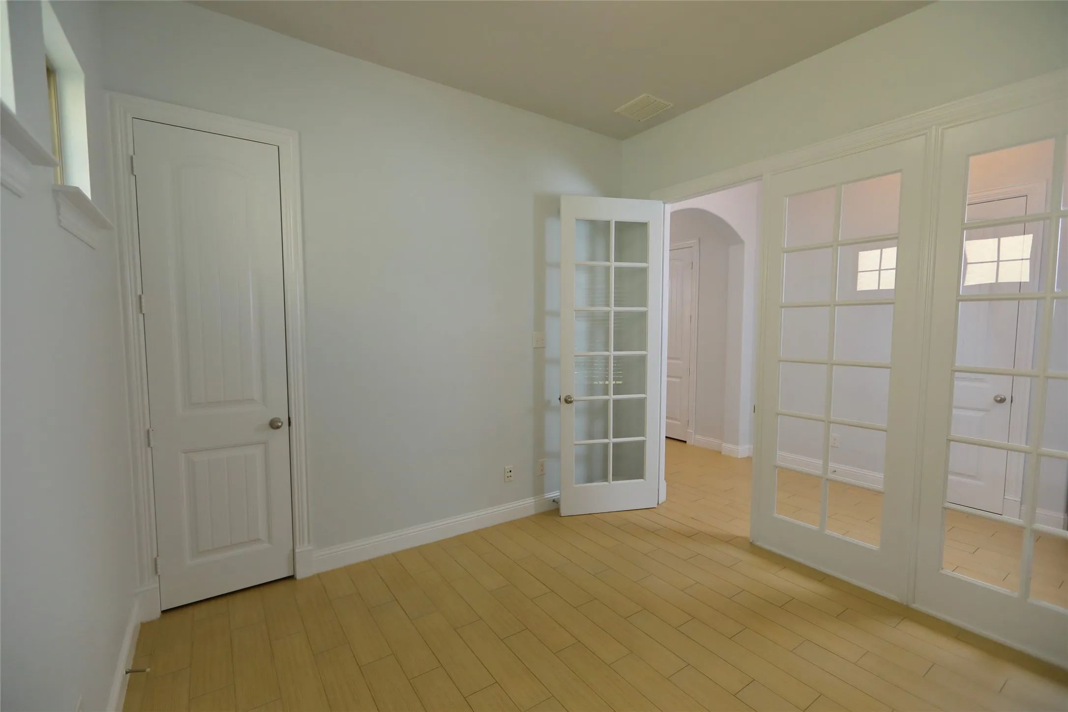 Room featuring wood-finish flooring, light wall paint, and white trim
