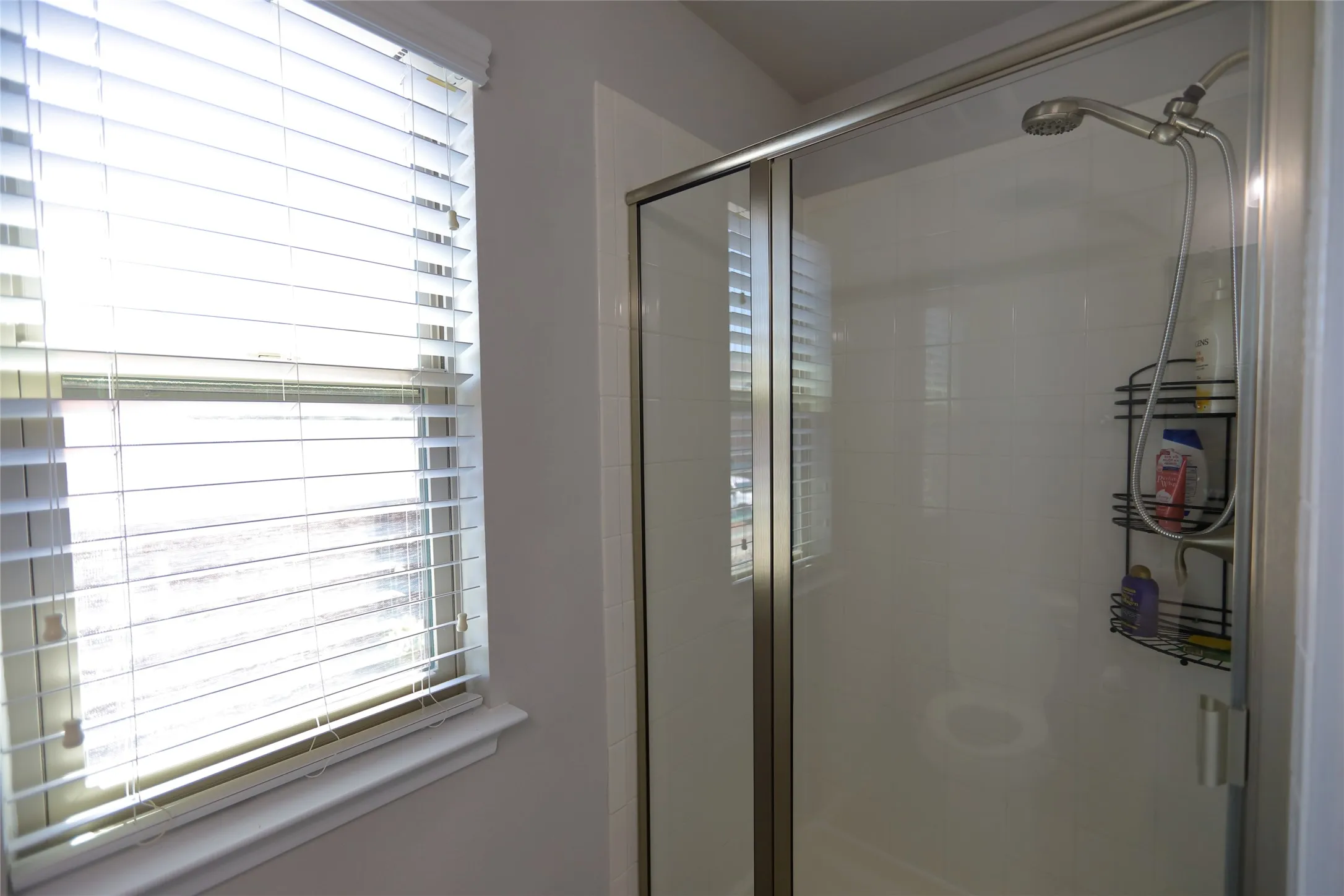 Shower stall featuring a glass enclosure and a handheld showerhead