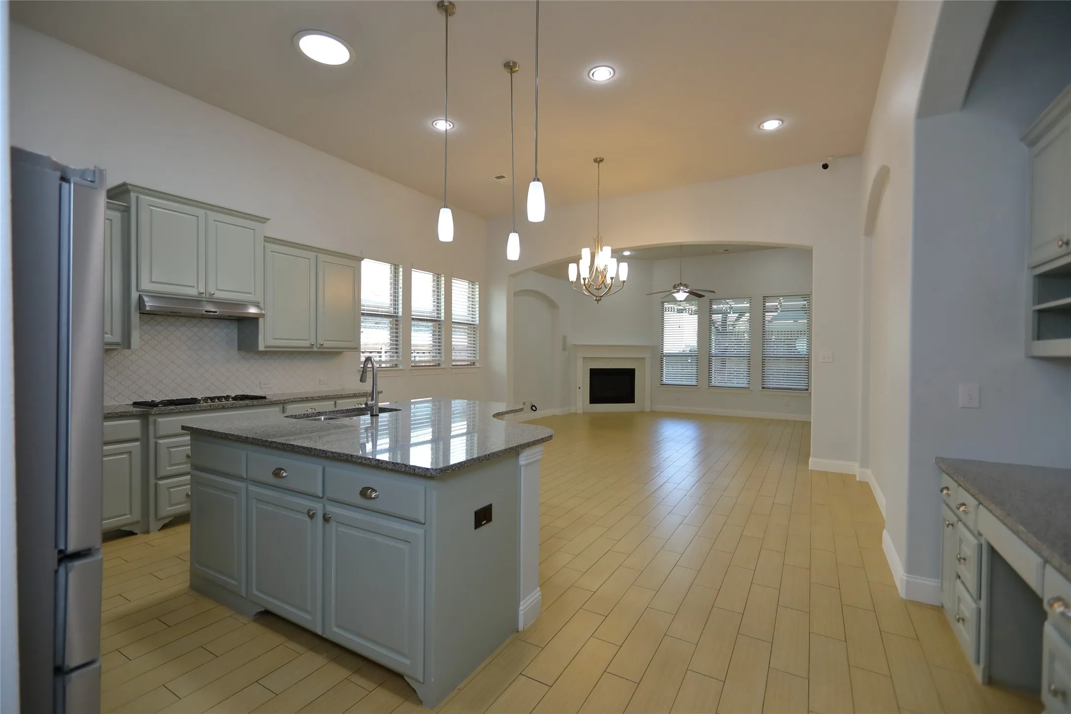 Kitchen featuring light gray cabinetry, stainless steel appliances, and a central island with a sink