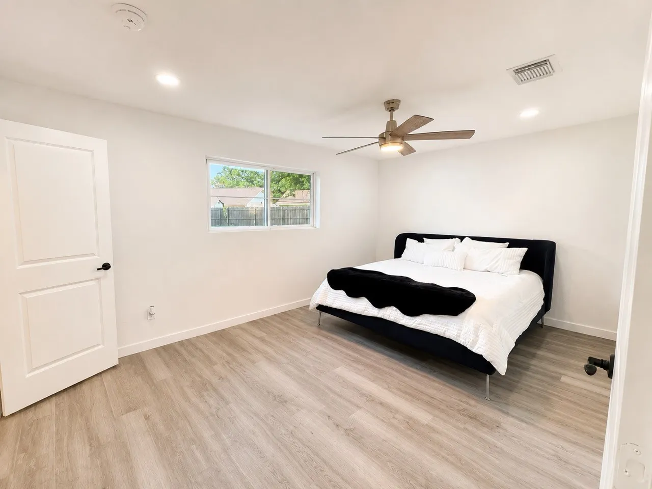 Recessed lighting, wood-finish flooring, white walls, and a ceiling fan