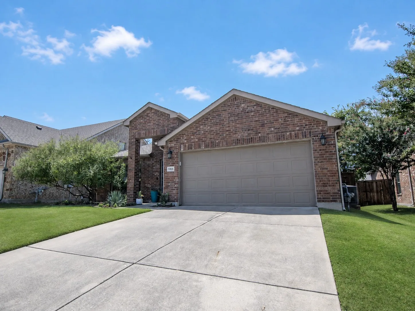 Brick-veneer exterior with a gabled roofline, concrete driveway, and attached two-car garage