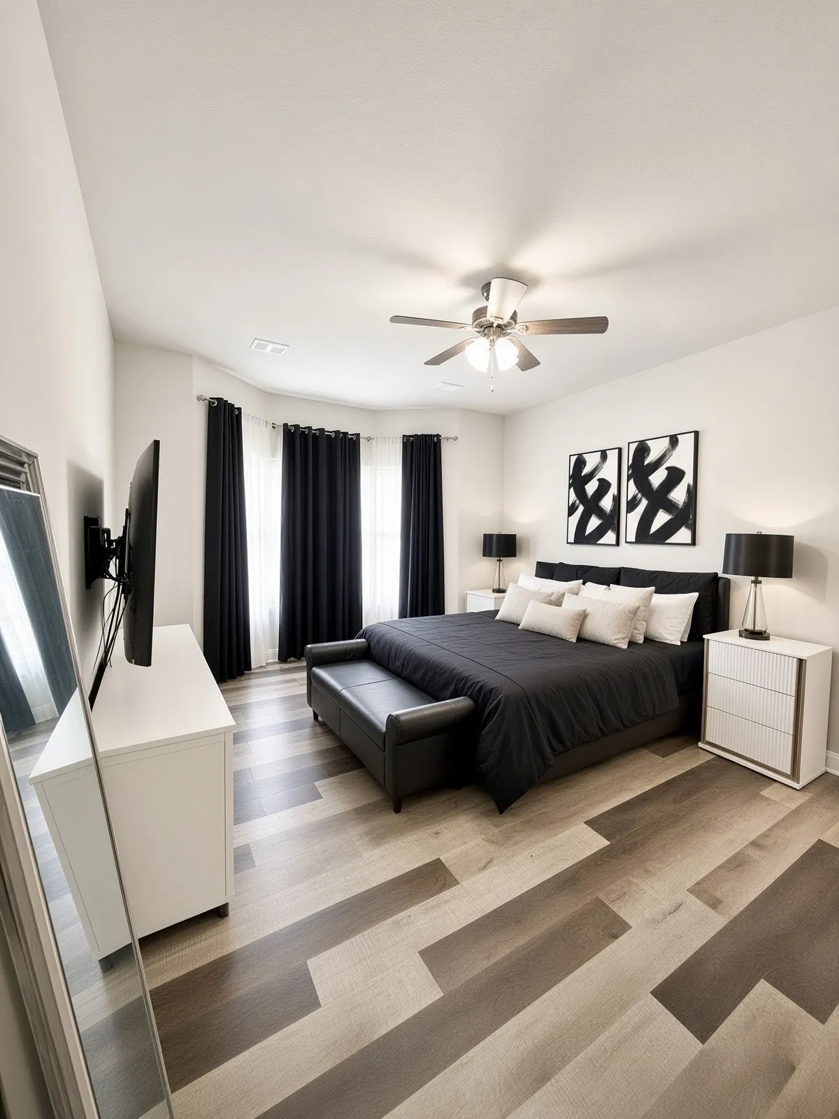 Spacious room with wood-finish flooring, a ceiling fan with integrated lighting, and bay windows