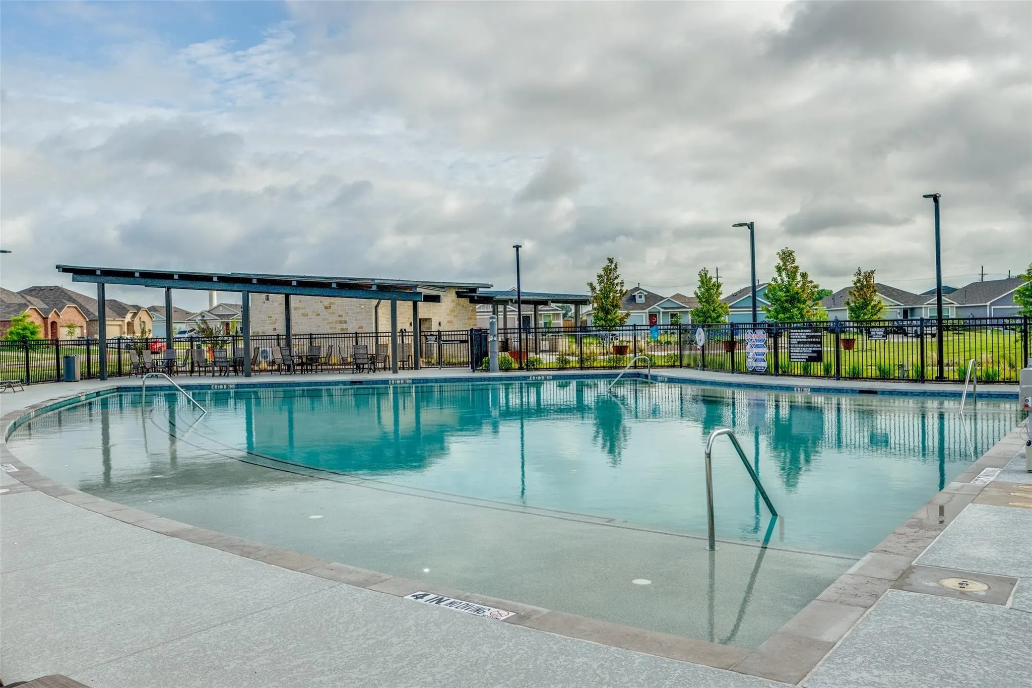 Community swimming pool featuring a curved design and integrated pool steps
