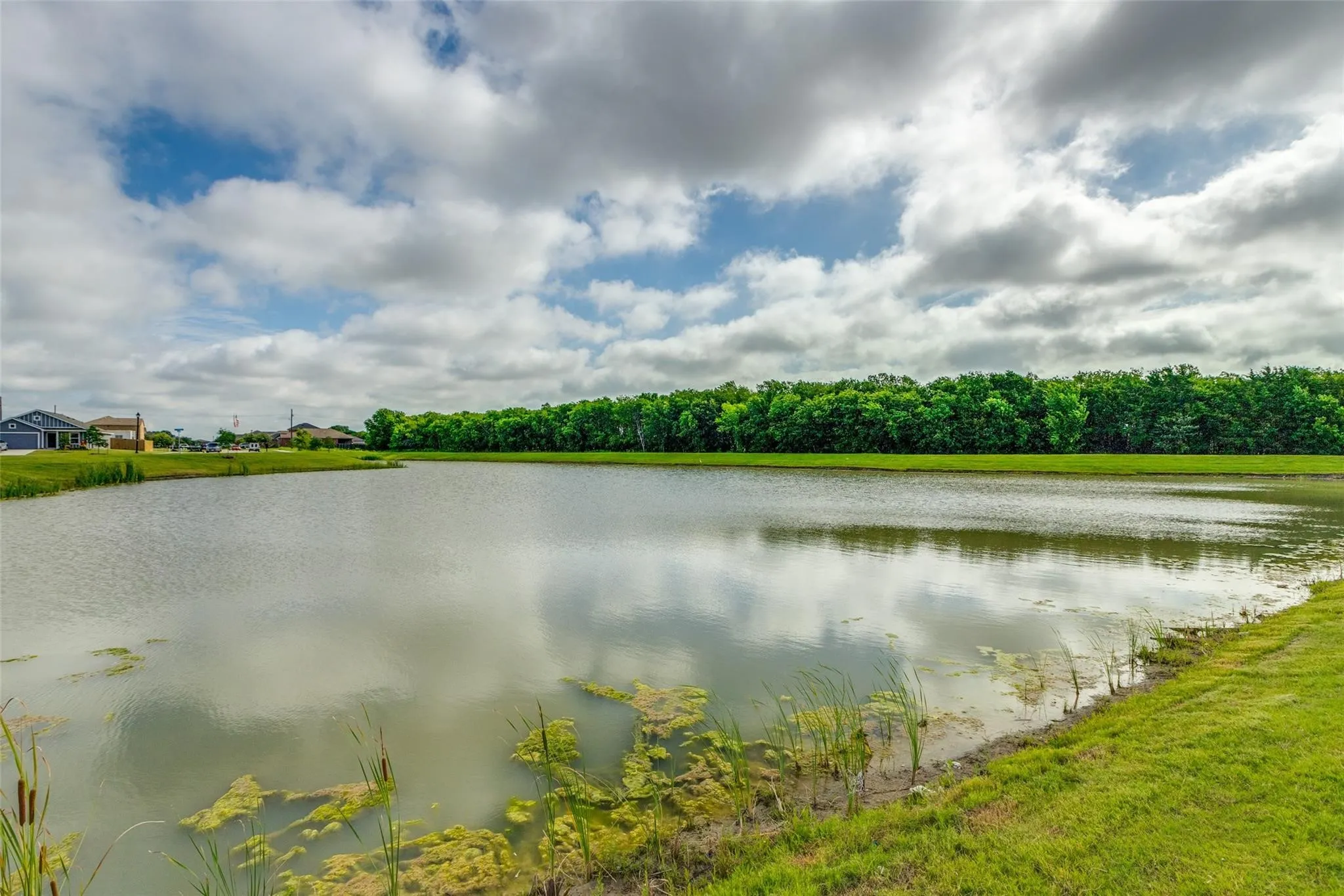 Expansive water feature with natural shoreline and lush green perimeter