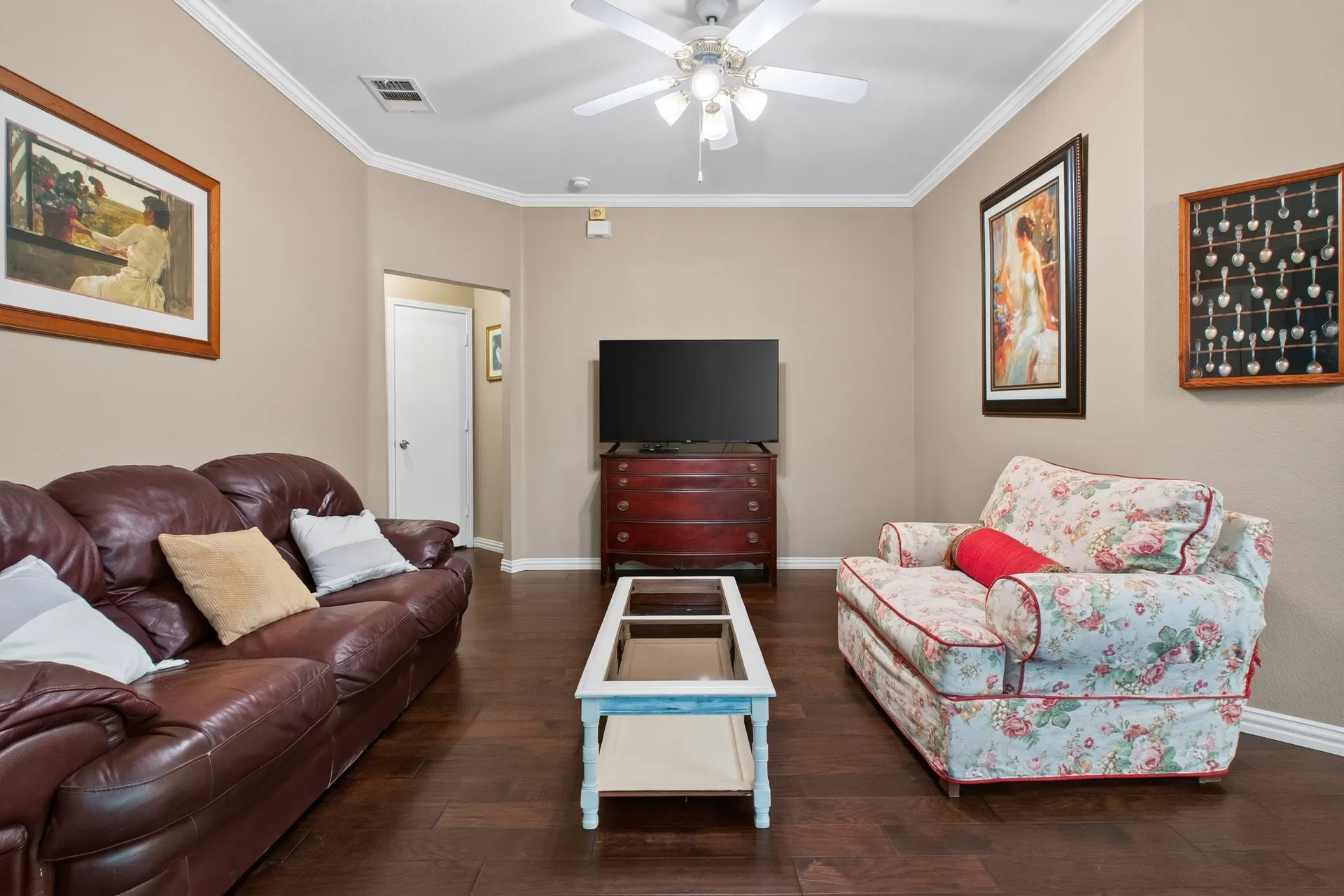 Crown molding accents the ceiling, complemented by a ceiling fan with integrated lighting