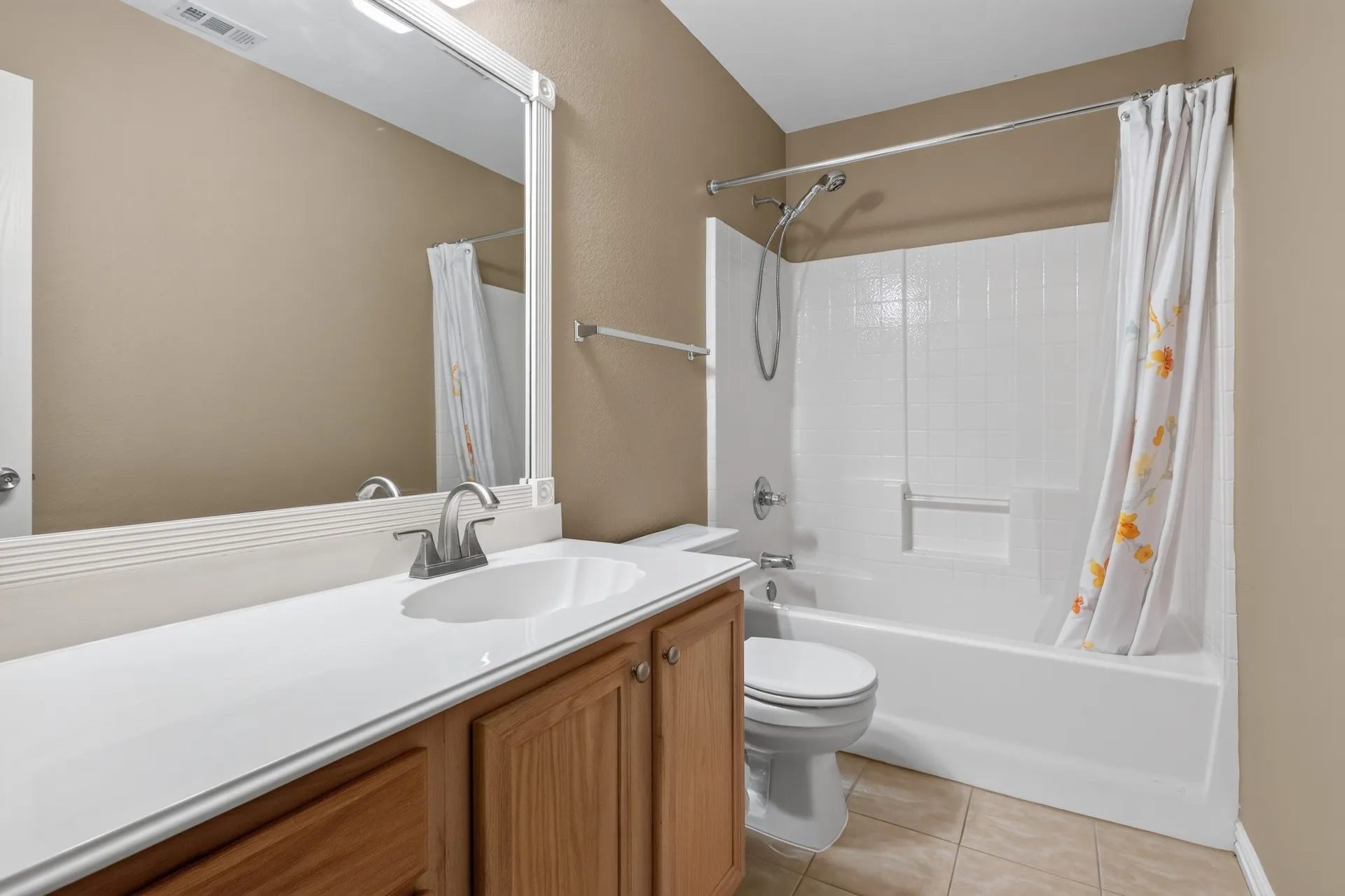 Single vanity with an integrated sink, wood-finish cabinetry, and a full-width mirror