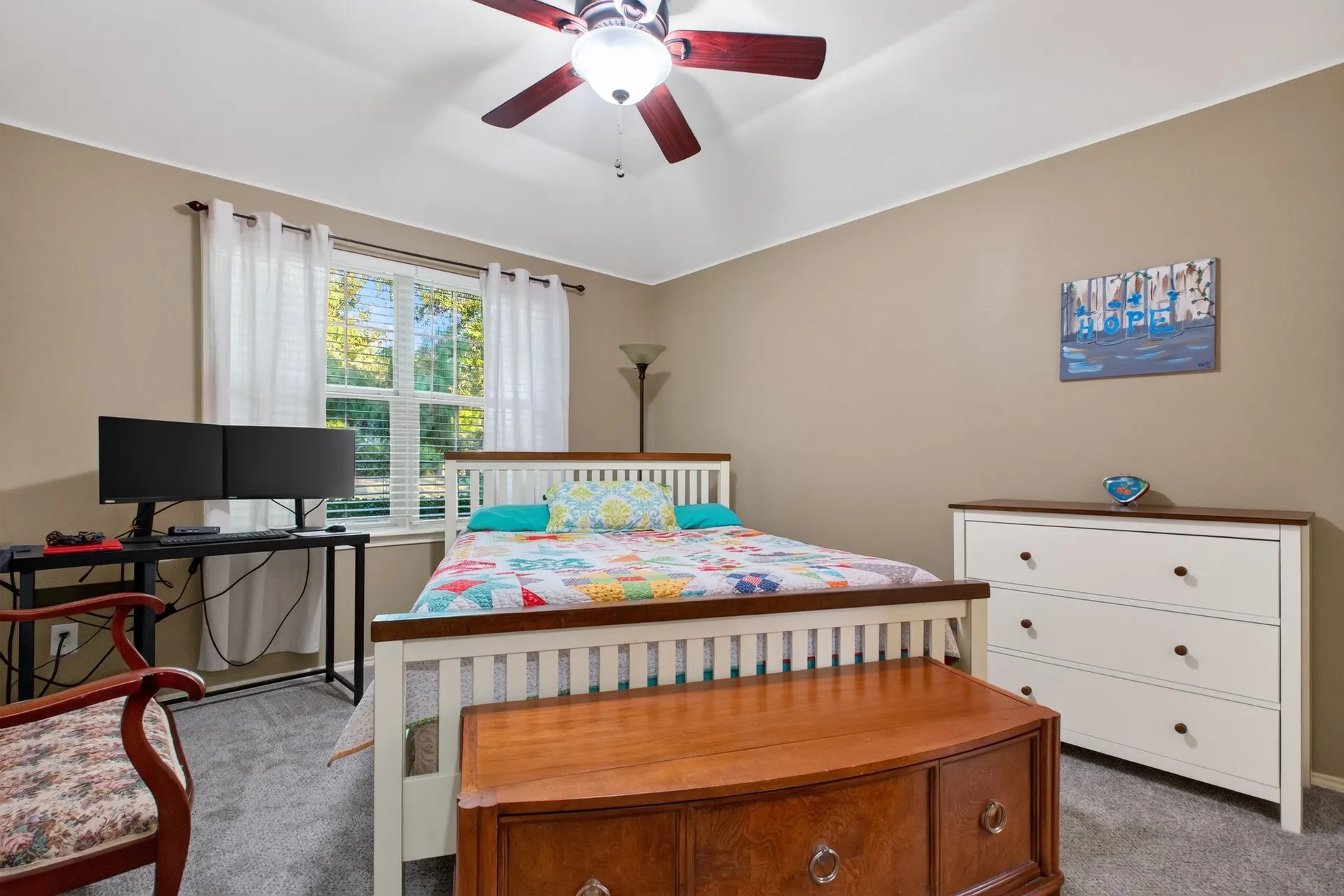 Neutral-toned walls complement the textured gray carpeting