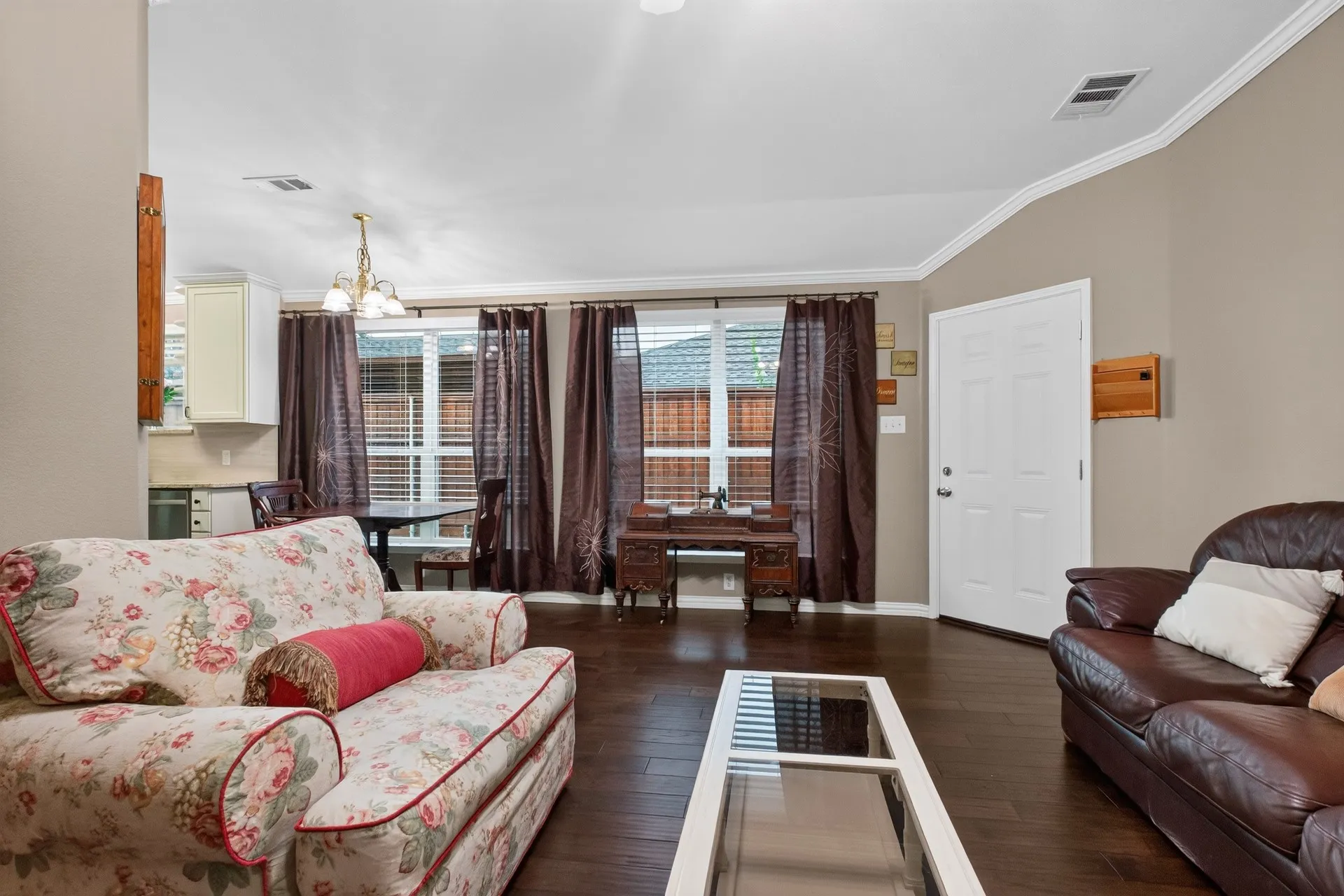 Hardwood-finish flooring throughout, crown molding detailing, recessed lighting, and a prominent front entry door