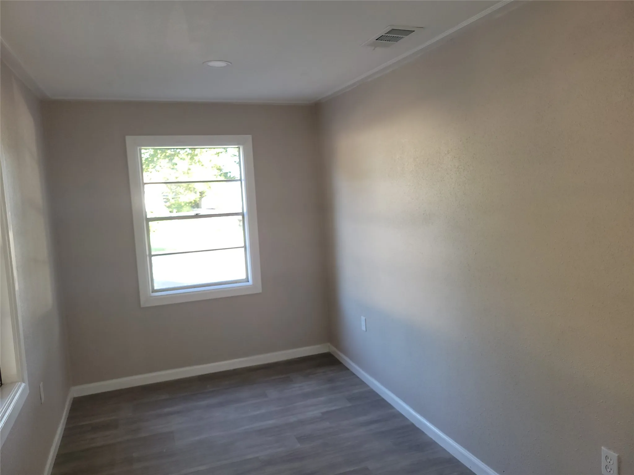 Recessed ceiling lighting, crown molding, double-pane window, wood-finish flooring, and light neutral wall tones