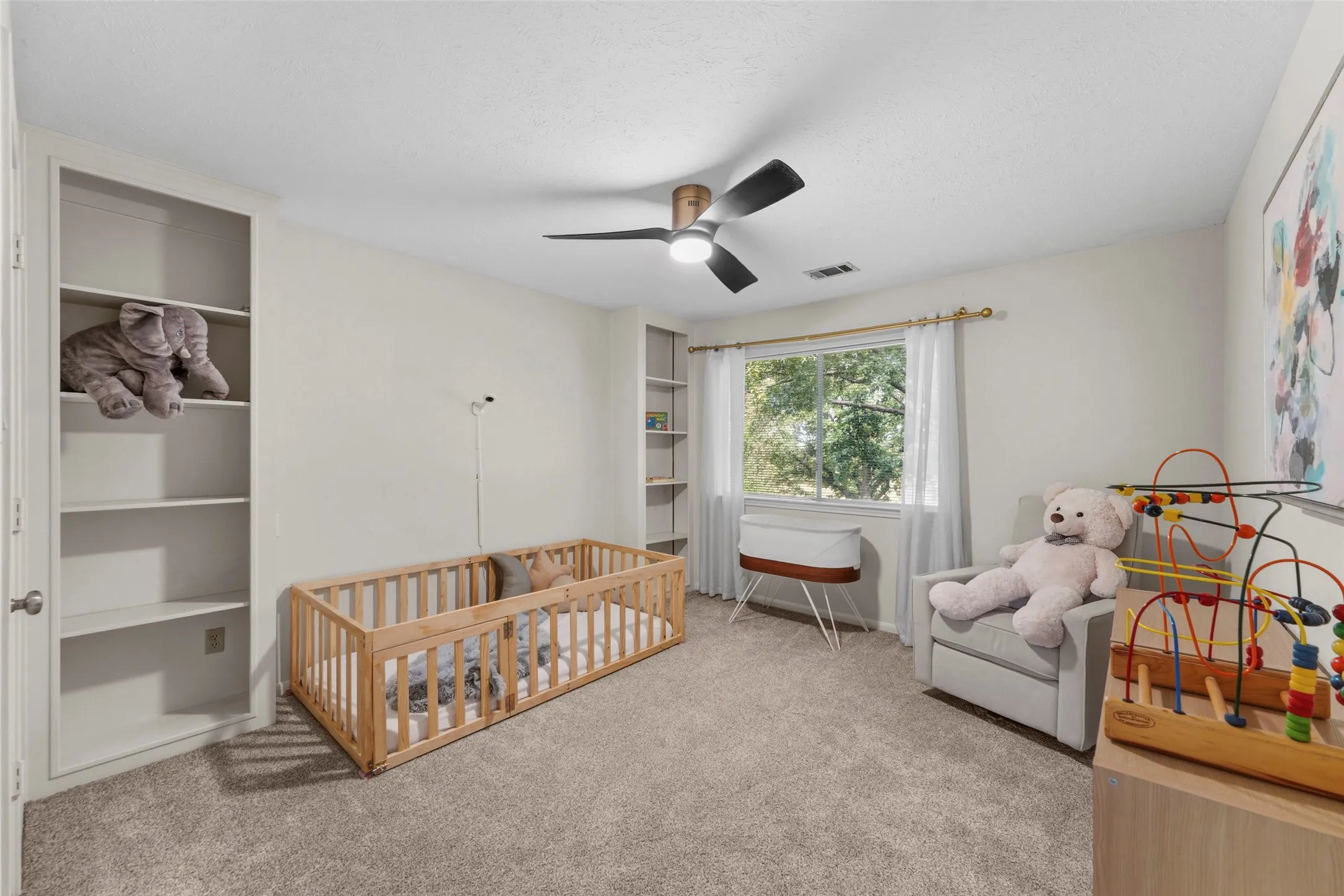 Wall-to-wall carpeting, built-in shelving, window with natural light, ceiling fan with integrated lighting