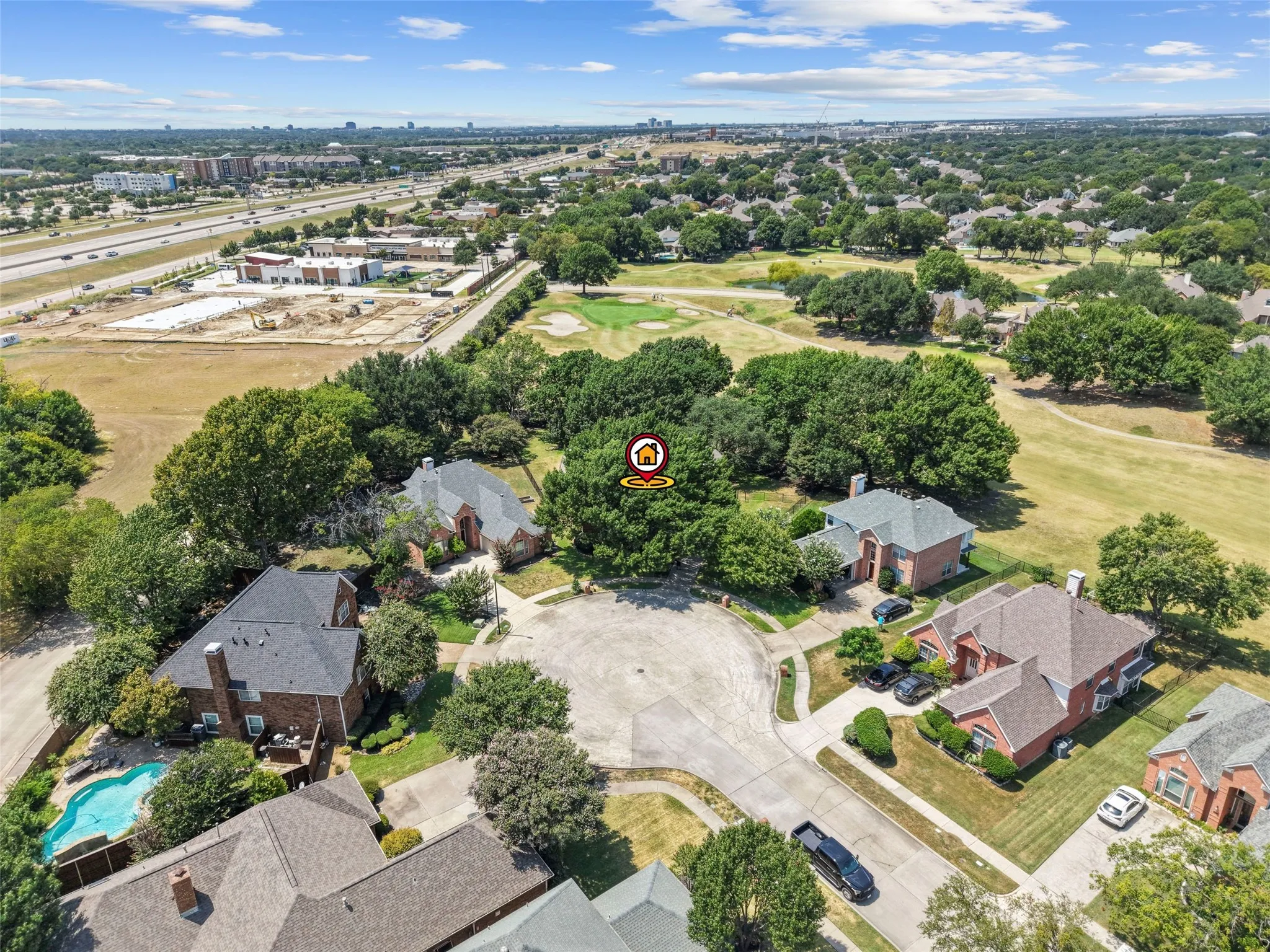 Aerial perspective showcasing a residential property with a private swimming pool, mature trees, and a cul-de-sac