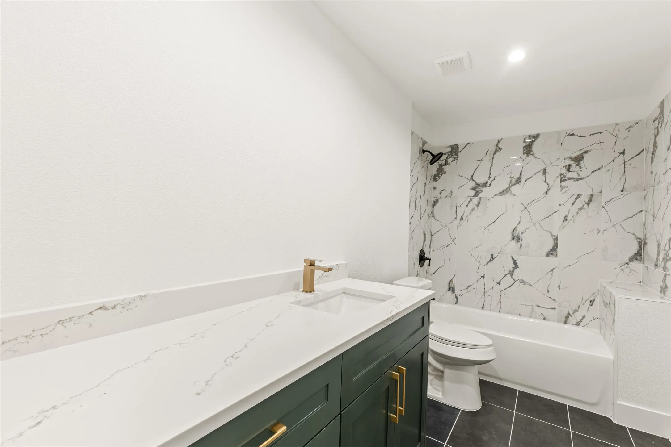 White vanity countertop with integrated sink and brass-finish faucet