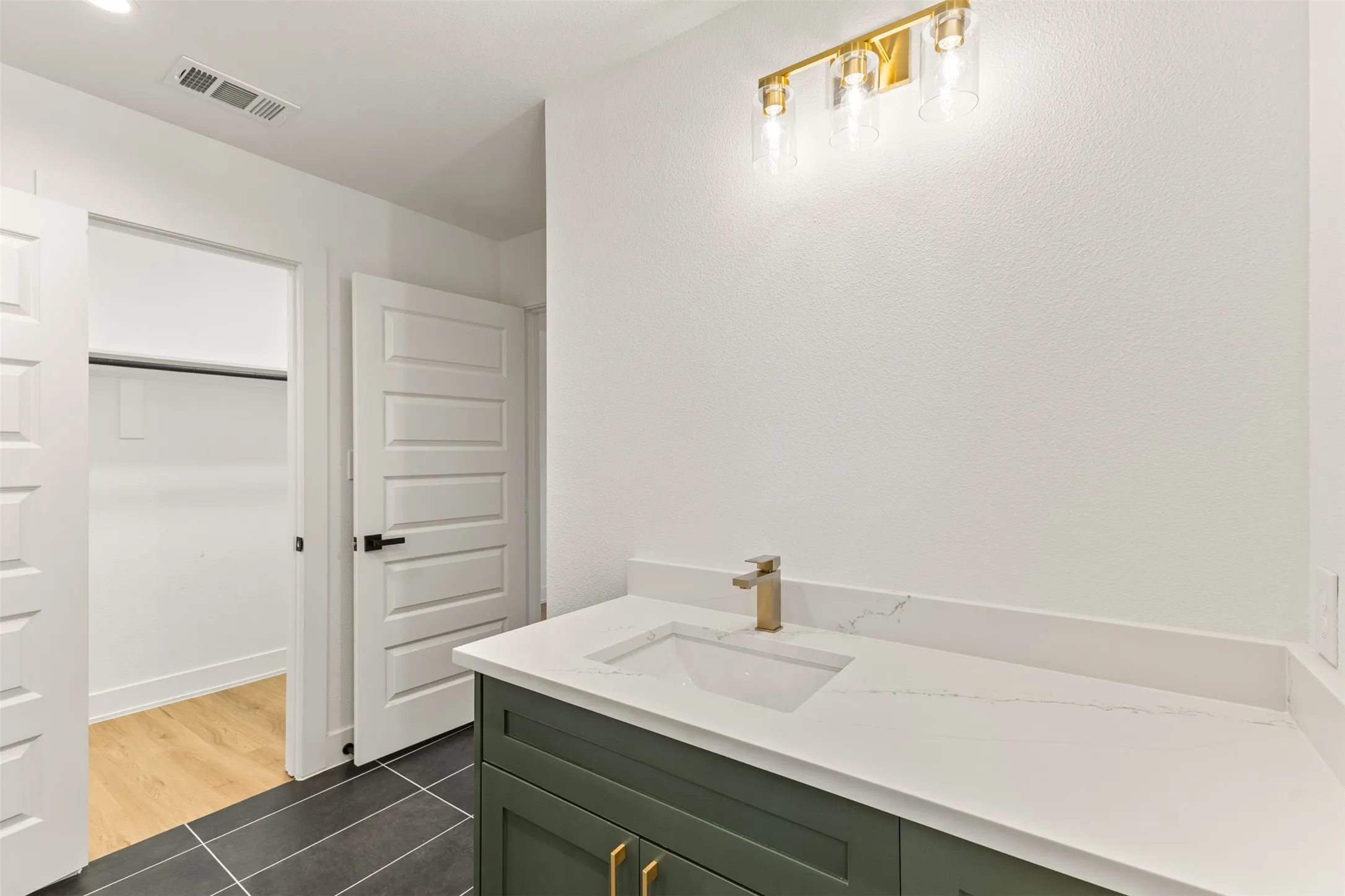 White countertop with an integrated sink and gold-finish faucet