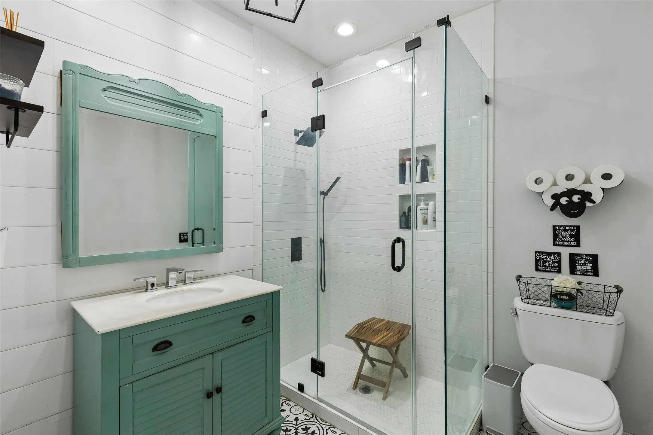 Glass-enclosed shower with subway tile, built-in recessed shelving, and a rain showerhead