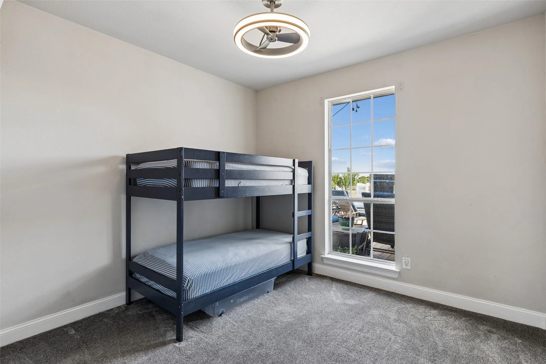Recessed lighting fixture, single pane window, carpeted flooring, light-toned walls