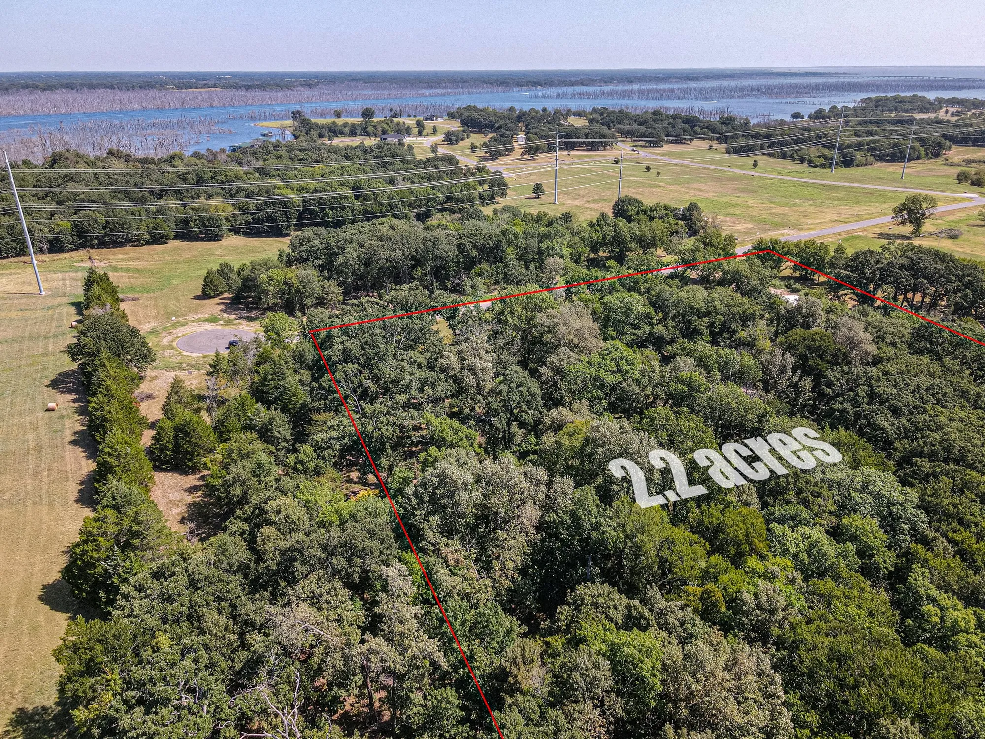Expansive 2.2-acre parcel featuring mature tree coverage, a cleared area, and proximity to a body of water